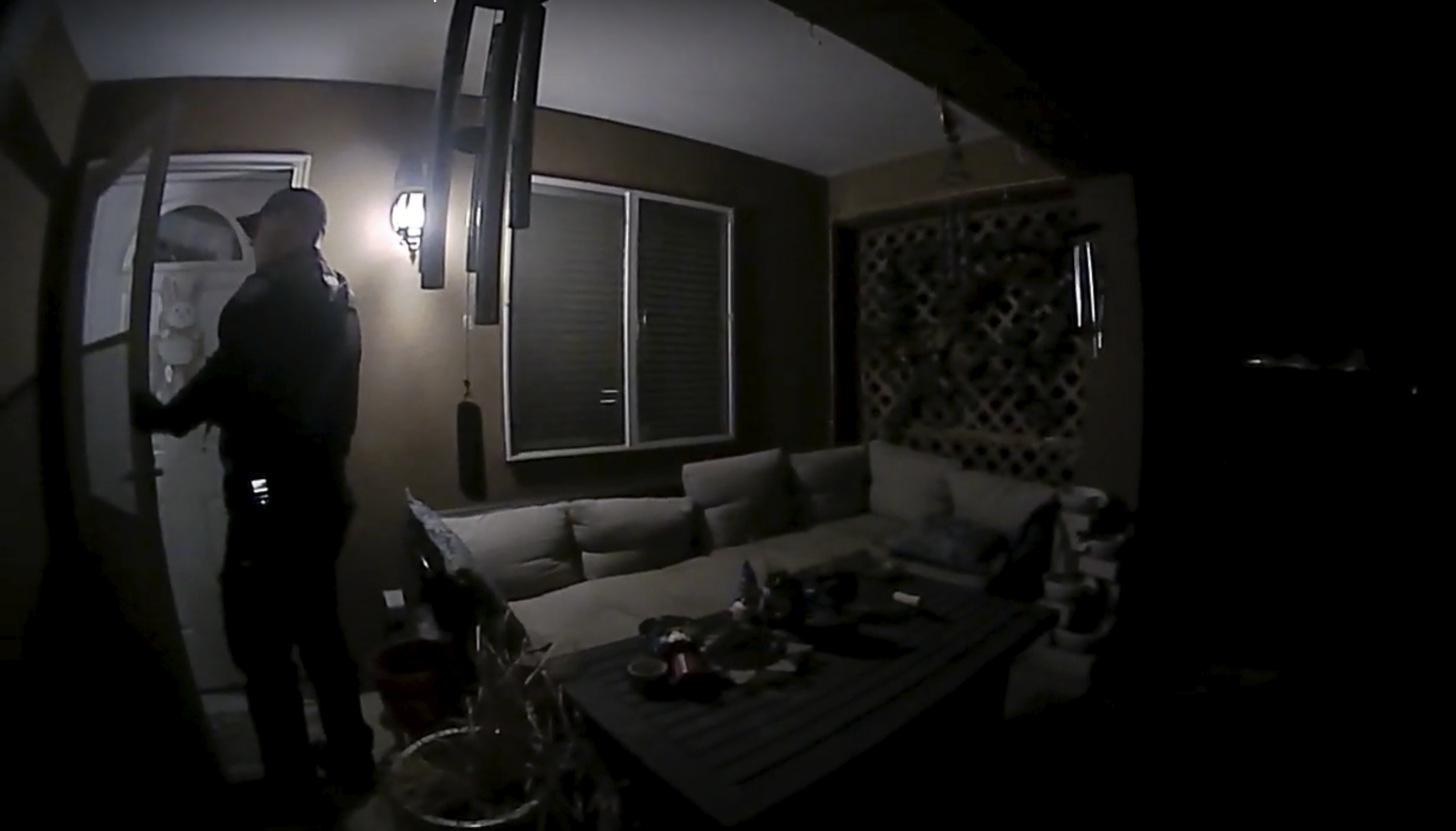 In this image taken from body camera video provided by the Farmington Police Department, a police officer knocks on the door of the wrong address in response to a domestic violence call