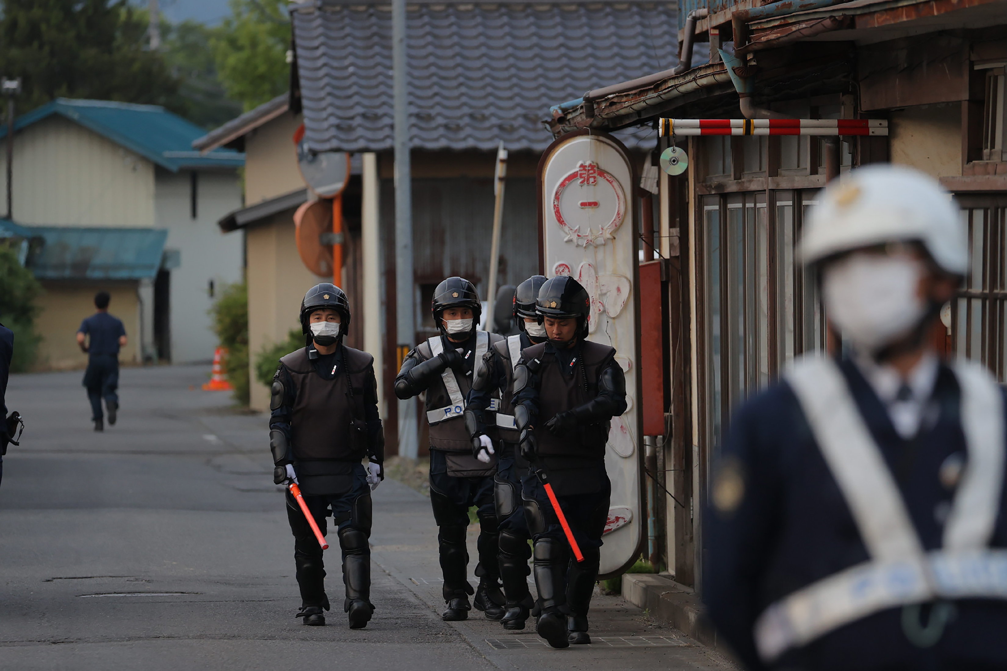 Police officers near the house where the suspect holed up after the attack in Nakano