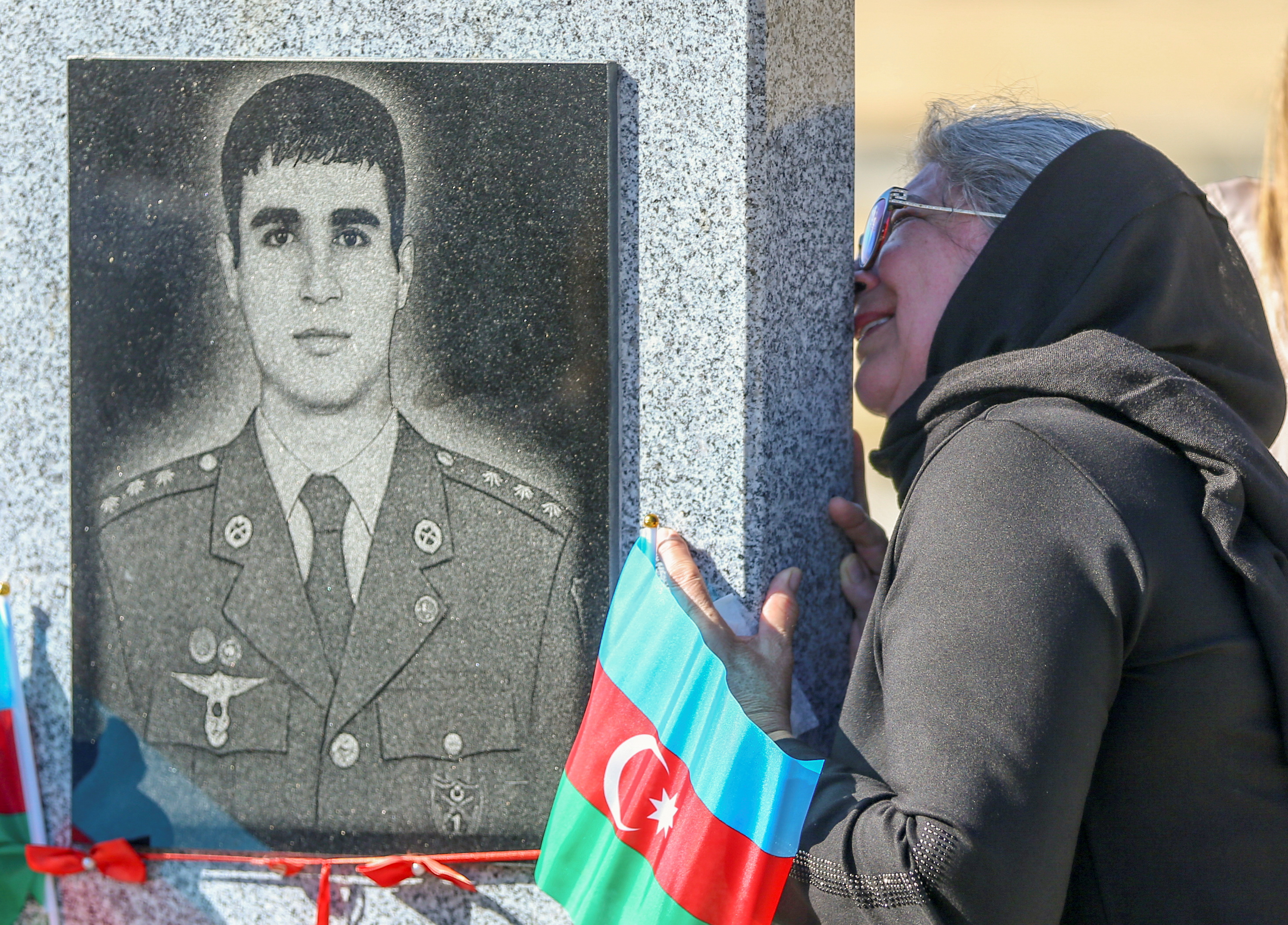 A woman grieves at a cemetery during a commemoration for Azeri service members killed in a conflict over the region of Nagorno-Karabakh