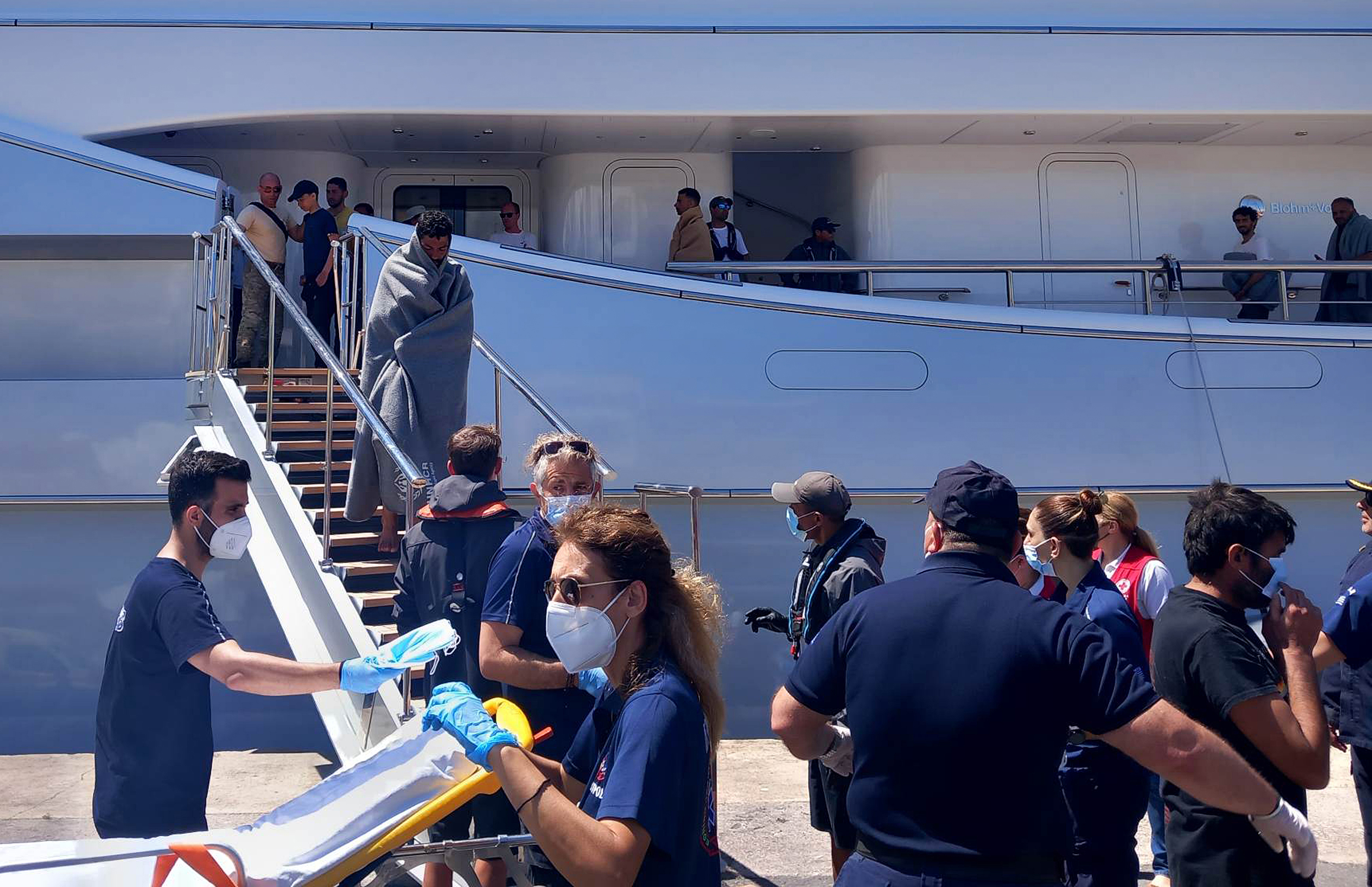 Paramedics of the Greek National Emergency Ambulance Service (EKAV) and members of the Greek Red Cross help refugees and migrants upon arrival at Kalamata’s port
