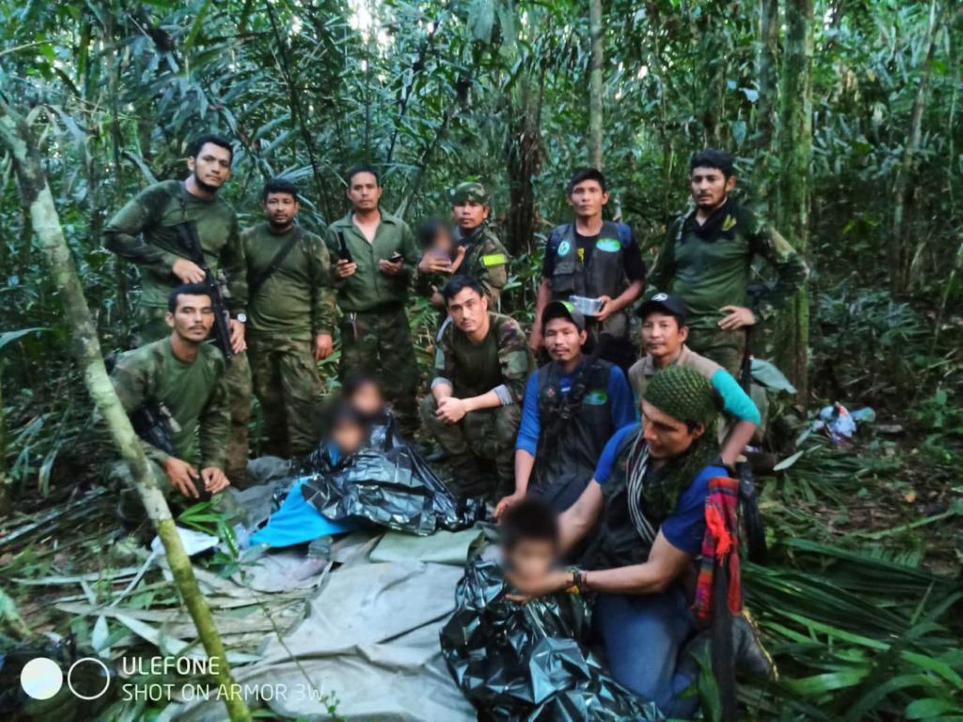 In this handout photo released on June 9, 2023, by the Colombian Presidency, members the Army pose with four Indigenous children who were found alive after spending more than a month lost in the Colombian Amazon jungle following the crash of a small plane