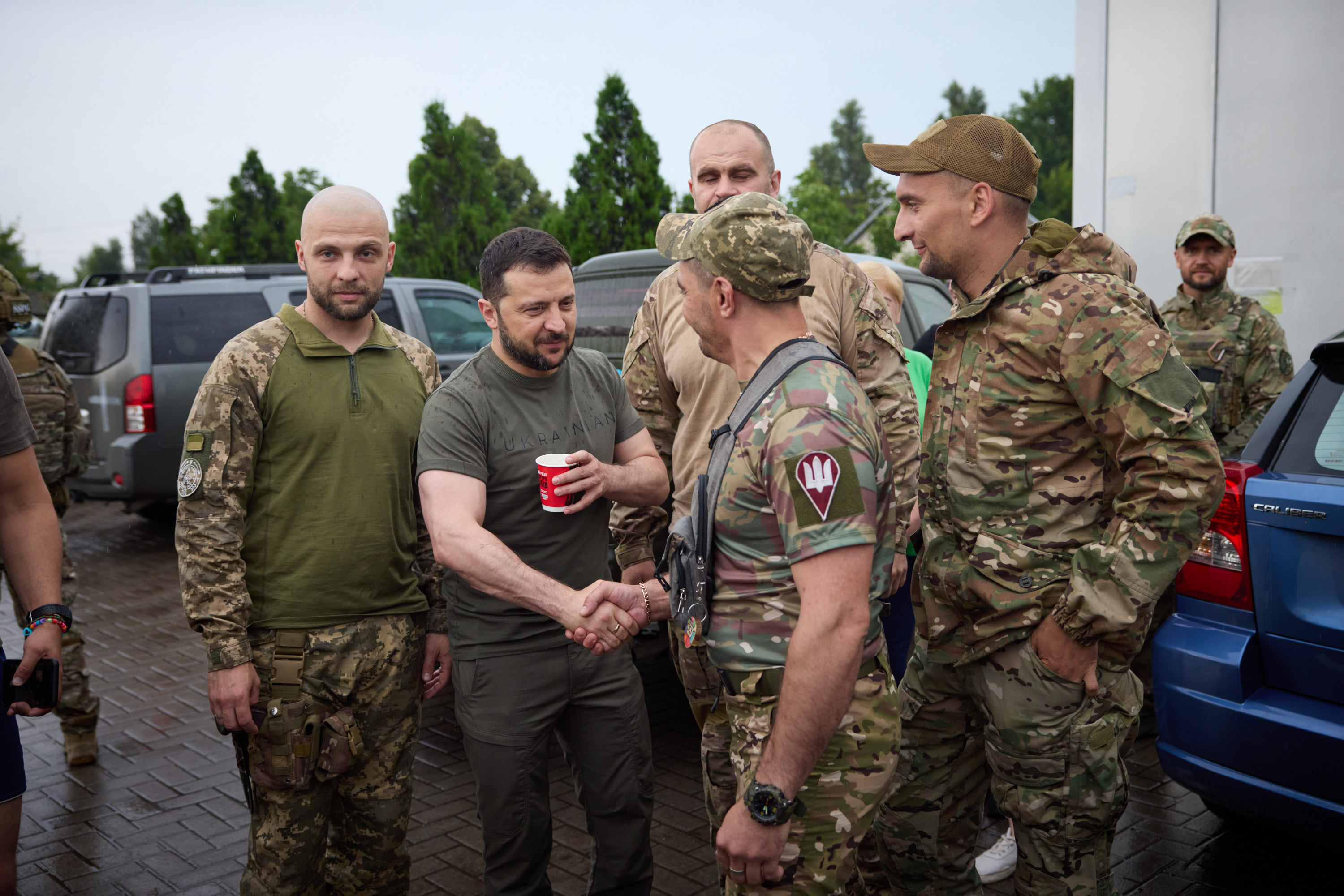 Ukrainian President Volodymyr Zelenskyy greeting soldiers at a petrol station during a visit to the eastern Donetsk region on Monday [Ukrainian Presidential Press Service via AFP]