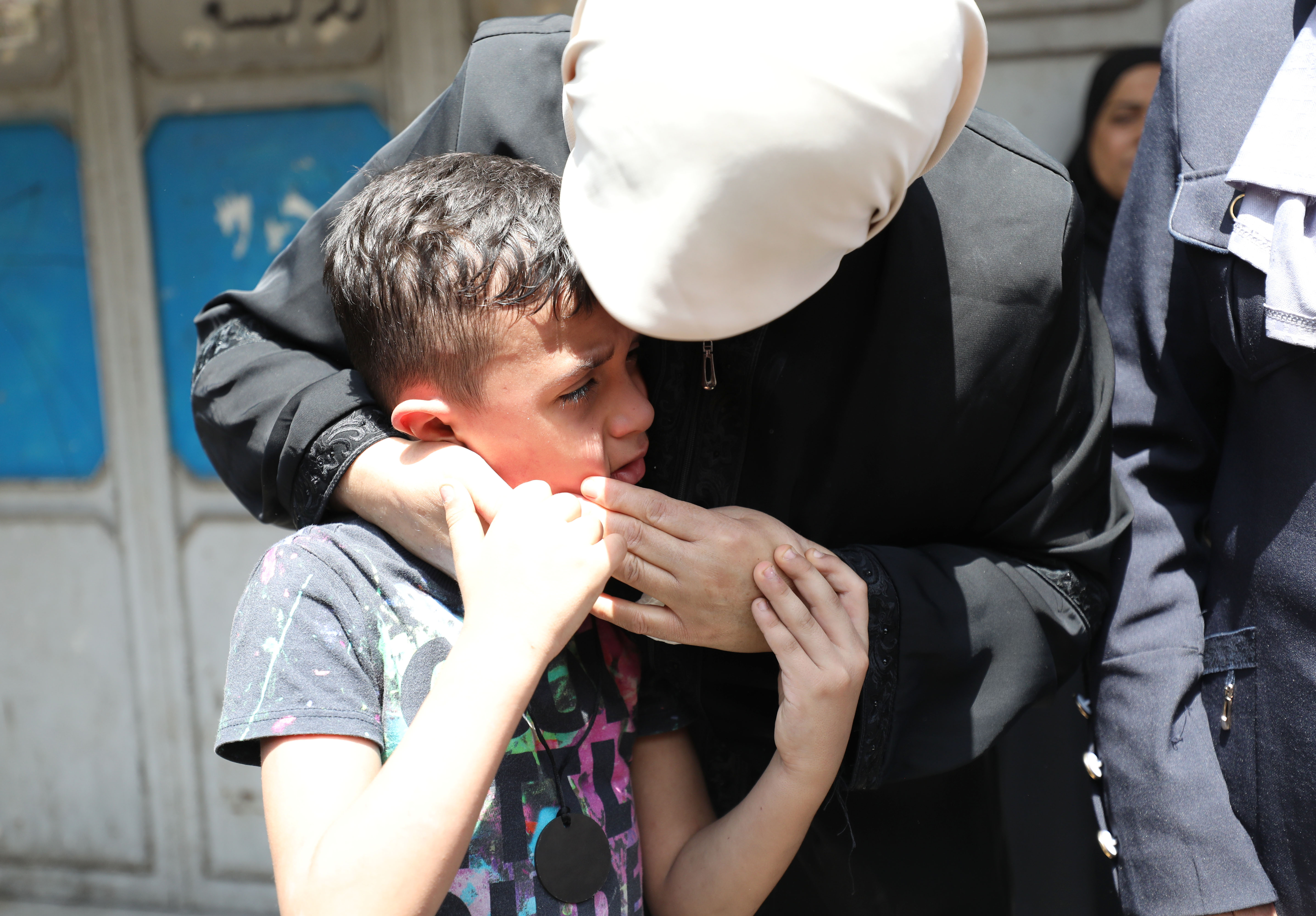 A crying Khaled is comforted