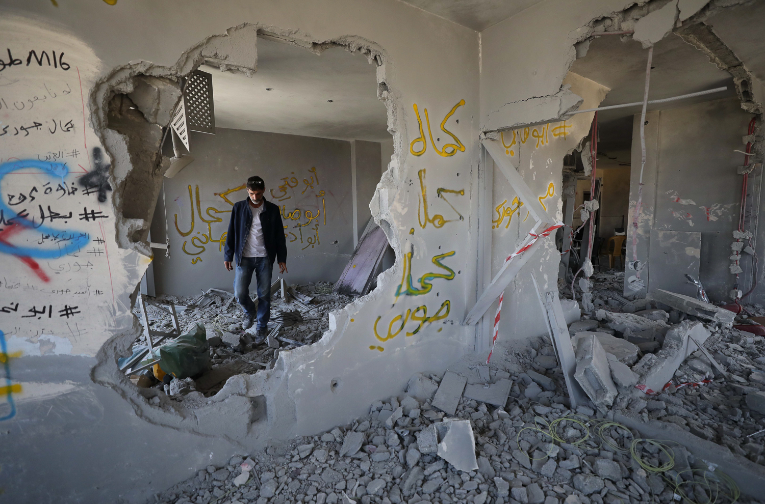 Hani al-Jouri looks at the wreckage of his home, stunned at the loss of the momentos of his children growing up there
