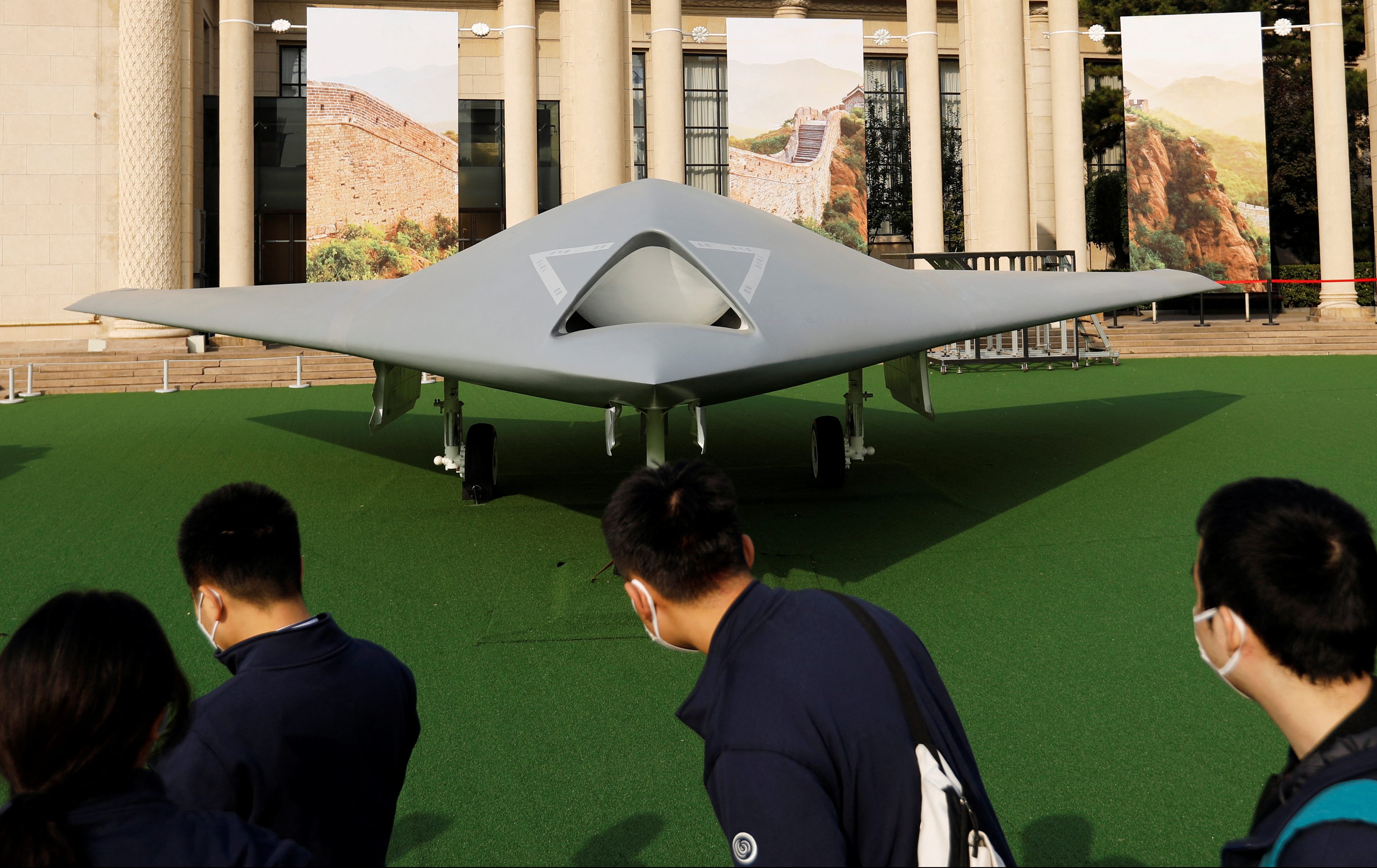 Visitors look at a display of GJ-11 stealth armed reconnaissance drone at an exhibition in Beijing