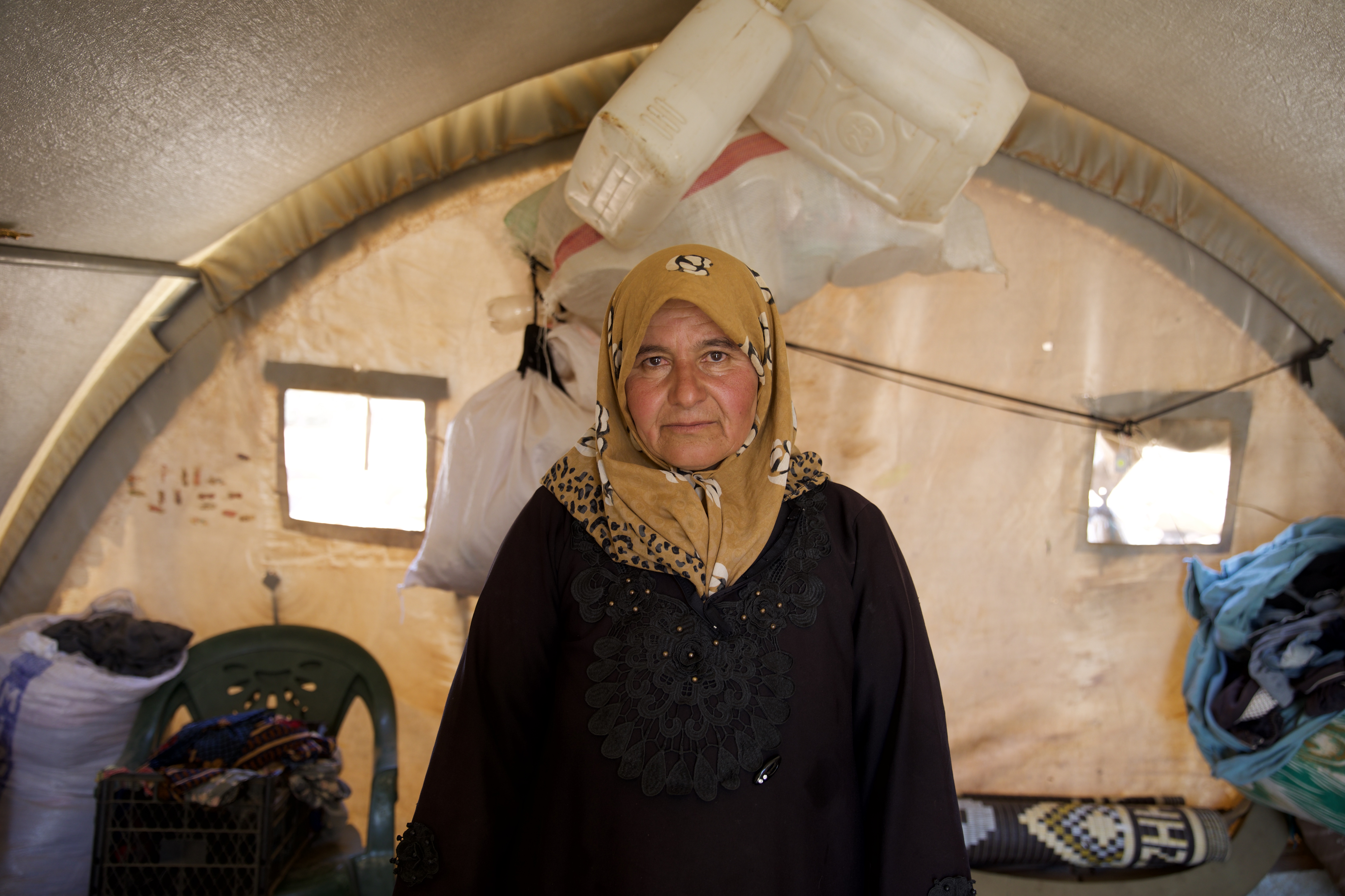 Since being displaced from their home, Aisha Eid and her children have been working for landowners in harvesting crops