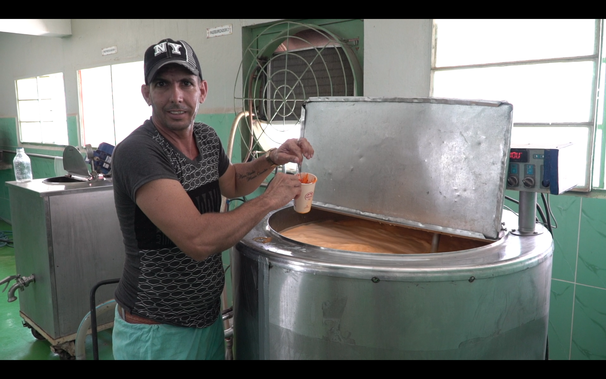 Rojas Dairy employee poses for photo next to pasturised and artificially coloured milk
