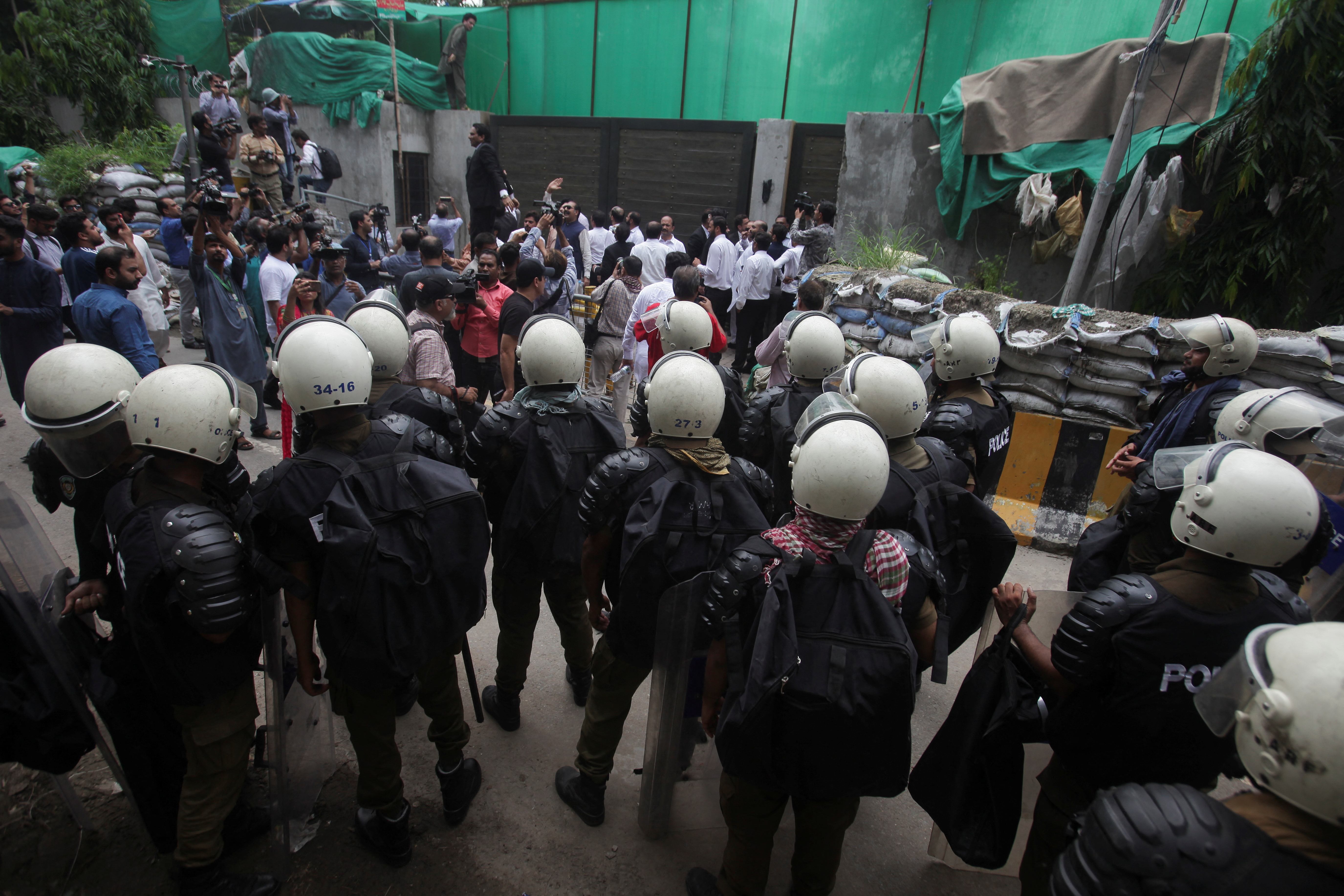 Police officers and members of the media gather following the arrest of Pakistan's former Prime Minister Imran Khan