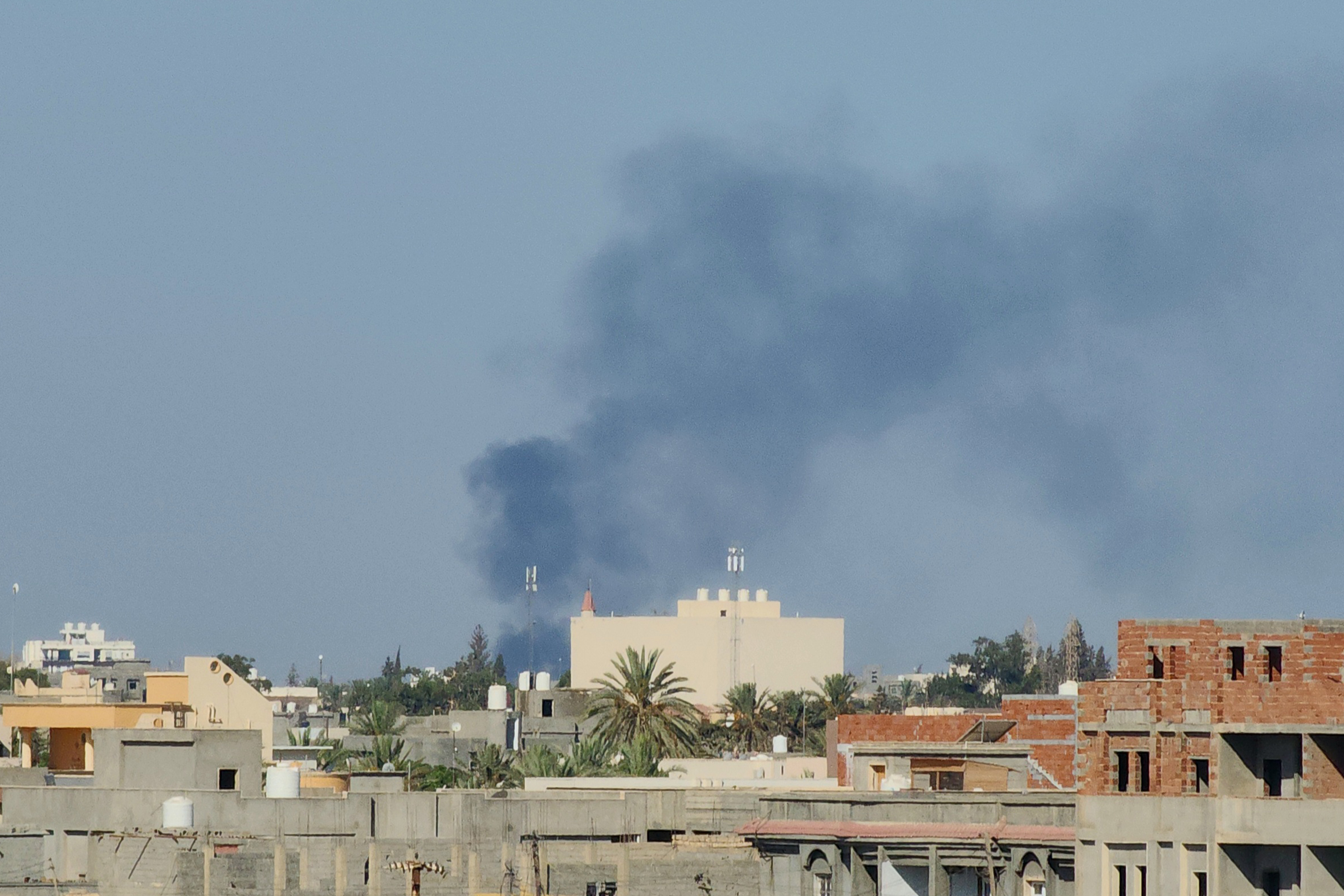 Smoke billows amid clashes between armed groups affiliated with Libya’s Tripoli-based Government of National Unity (GNU) in the Libyan capital