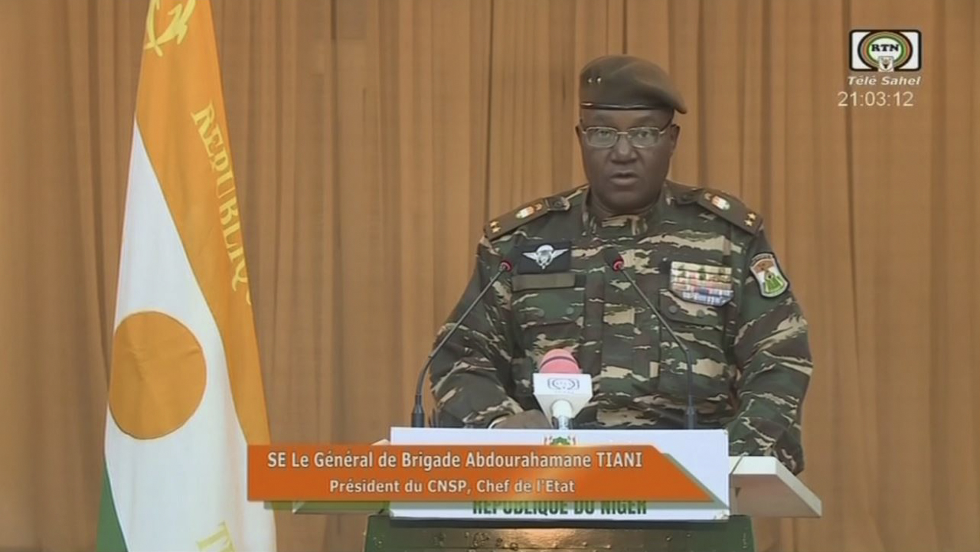 Niger's new military ruler General Abdourahamane Tiani reads a statement on national television