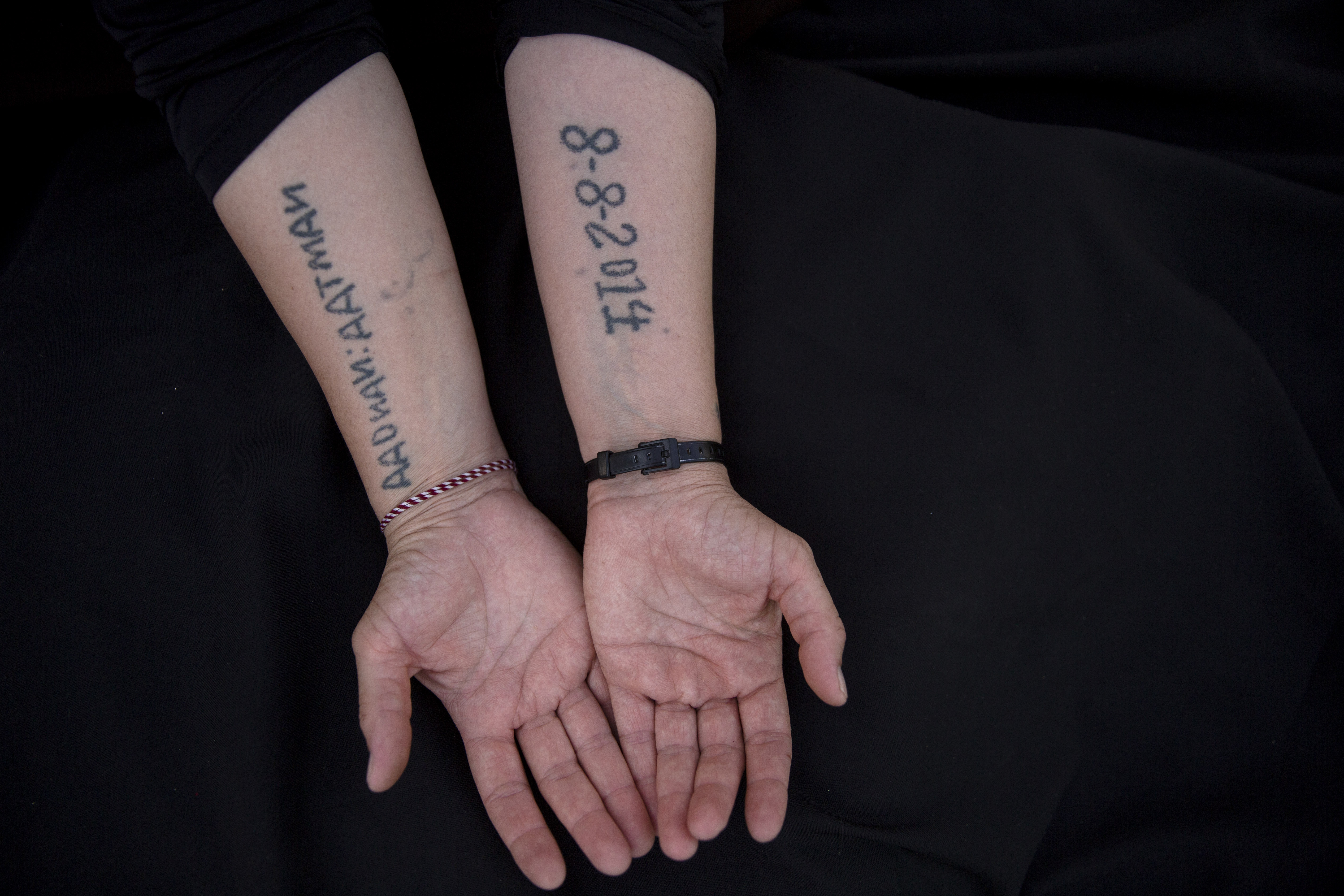 Leila Shamo displays tattoos she made while enslaved by ISIL fighters at her home near Khanke camp, near Dohuk, Iraq. Shamo, 34, wrote the names of her husband and two sons on her right forearm. On the inside of her left forearm, she wrote the date ISIL captured them all together; August 8, 2014