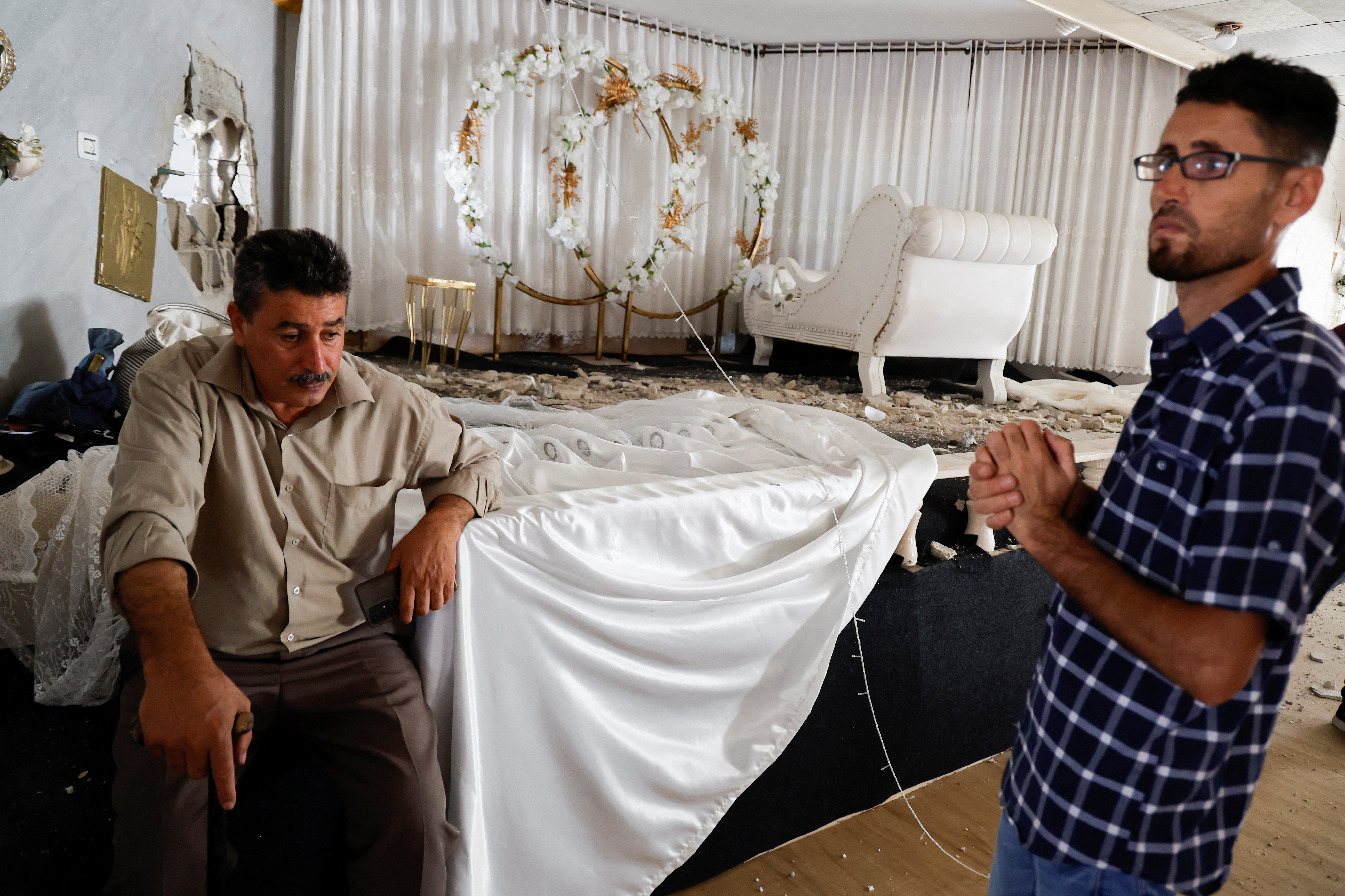 Palestinians inspect the house where a Palestinian militant was hiding which was destroyed by missiles during an Israeli raid 