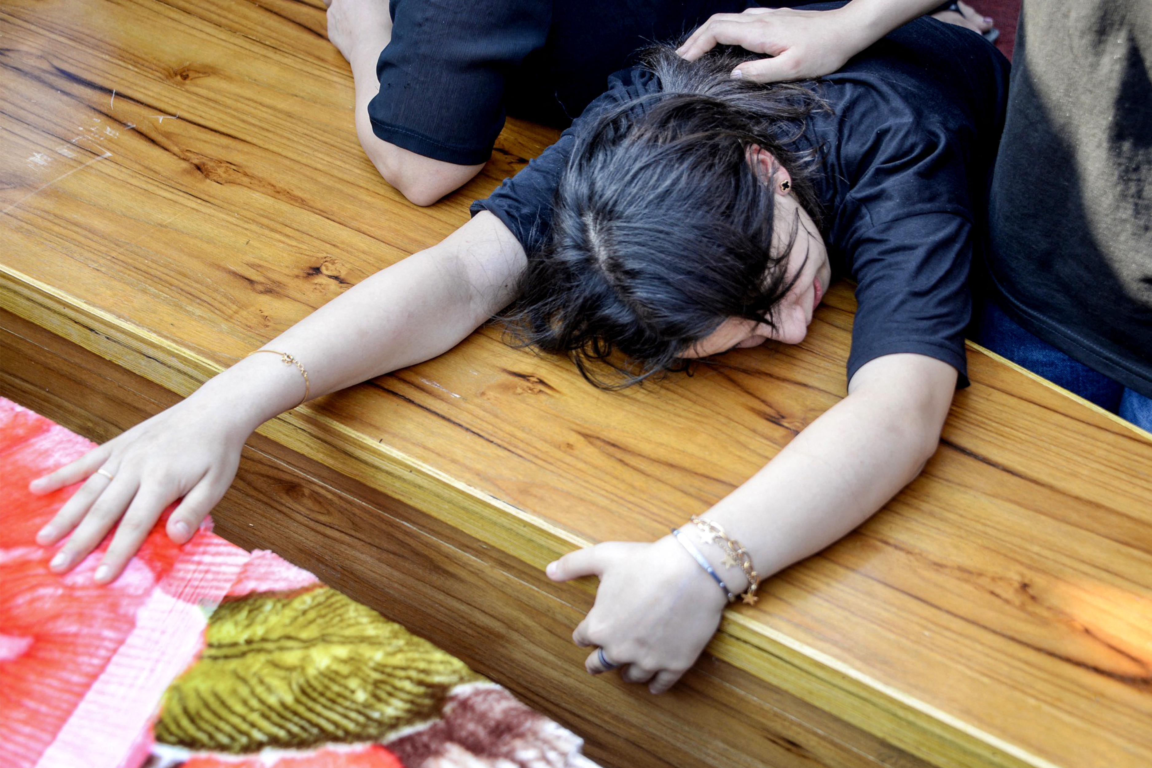 Woman mourns over a coffin.
