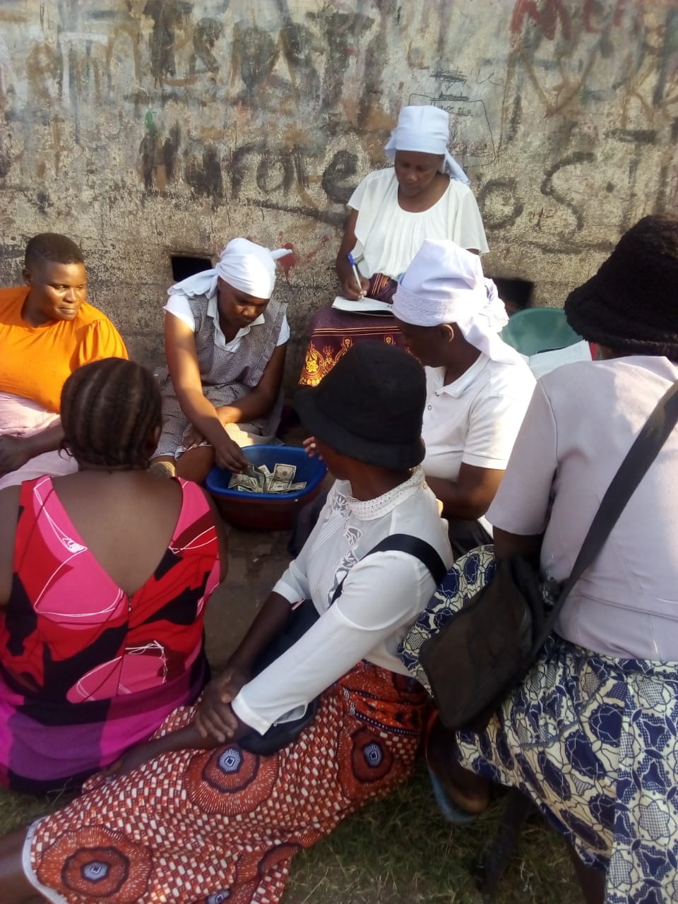 Unity collects money at a weekly meeting of her informal savings club
