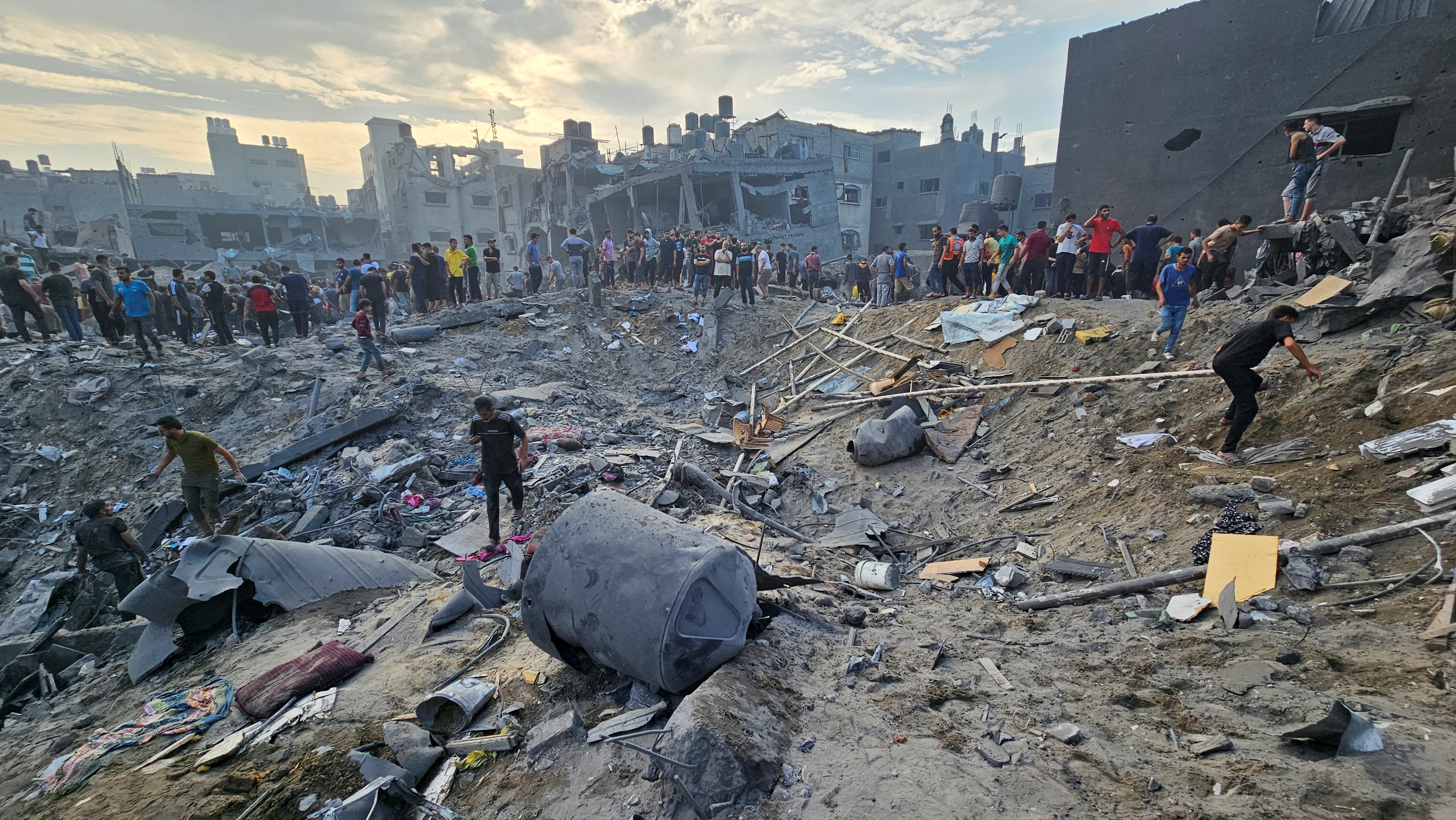 Palestinians search for casualties at the site of Israeli strikes on houses in Jabalia refugee camp in the northern Gaza Strip