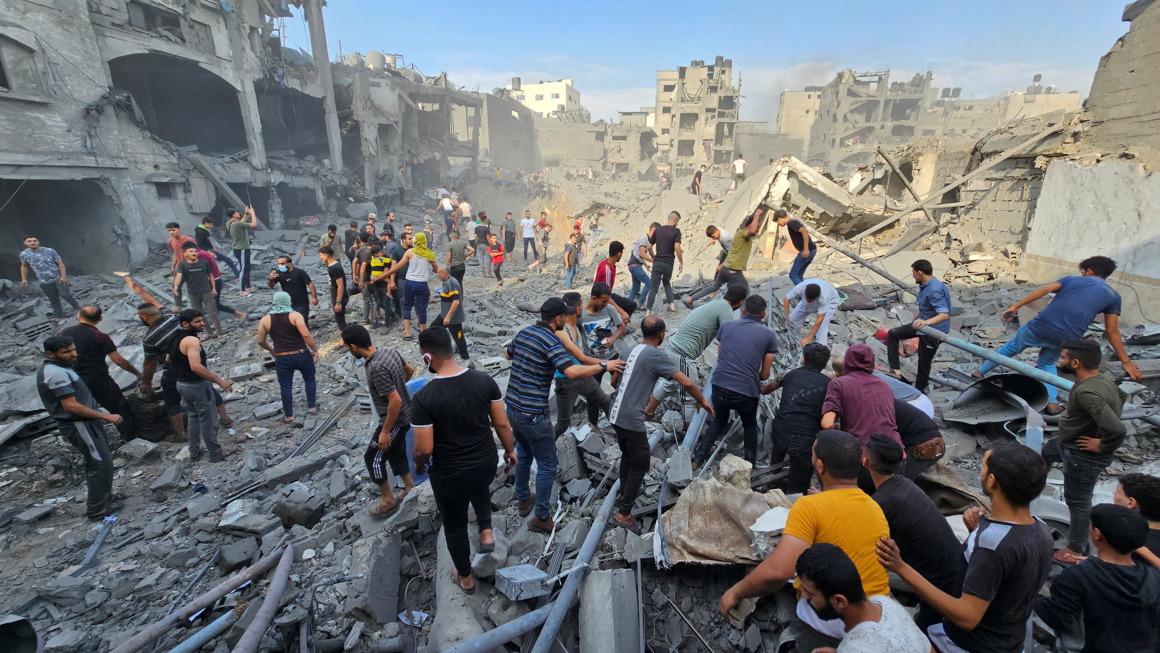 Palestinians search for casualties at the site of Israeli strikes on houses in Jabalia refugee camp in the northern Gaza Strip