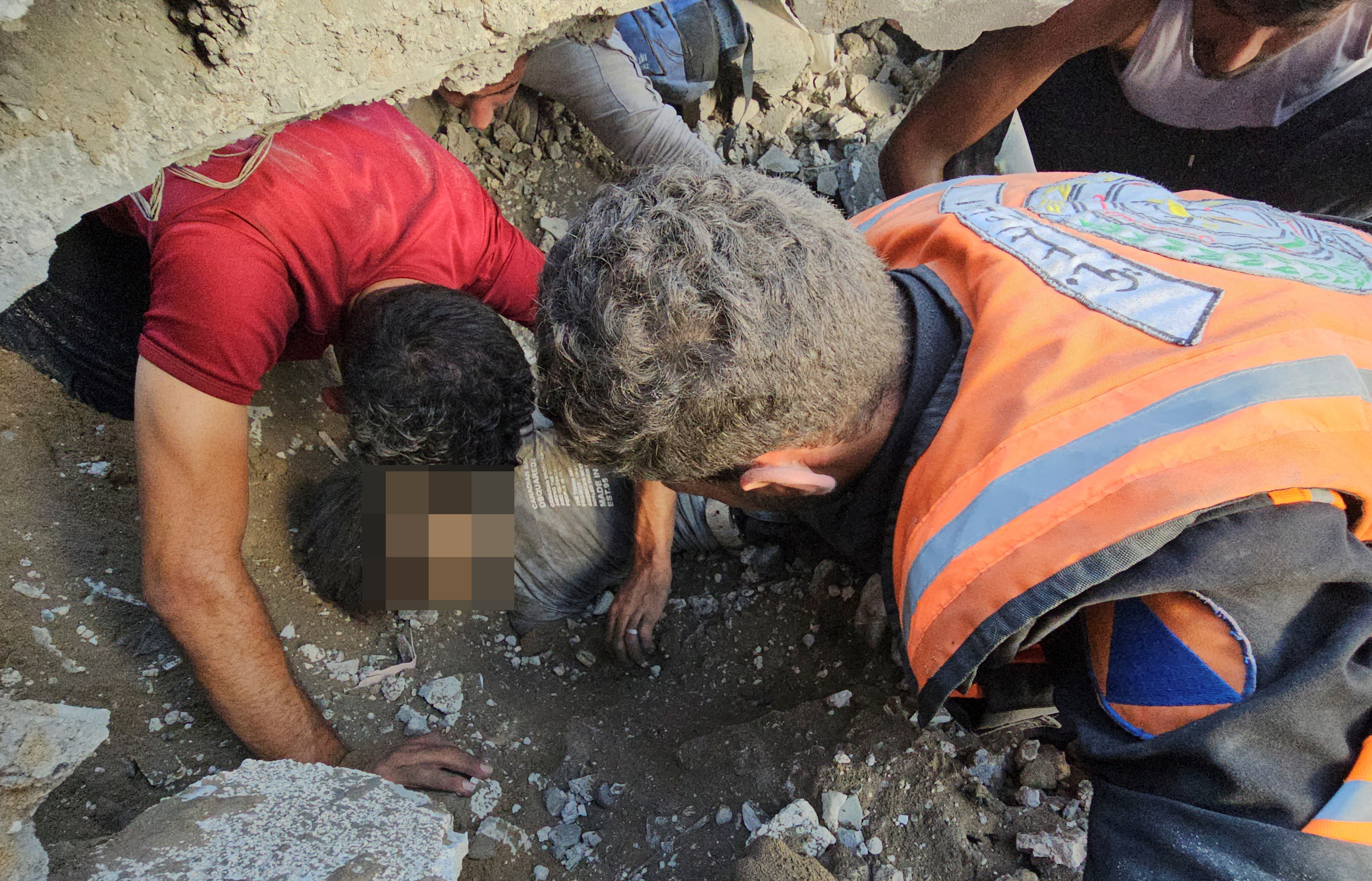 Palestinians work on the rescue of a casualty at the site of Israeli strikes on houses in Jabalia refugee camp in the northern Gaza