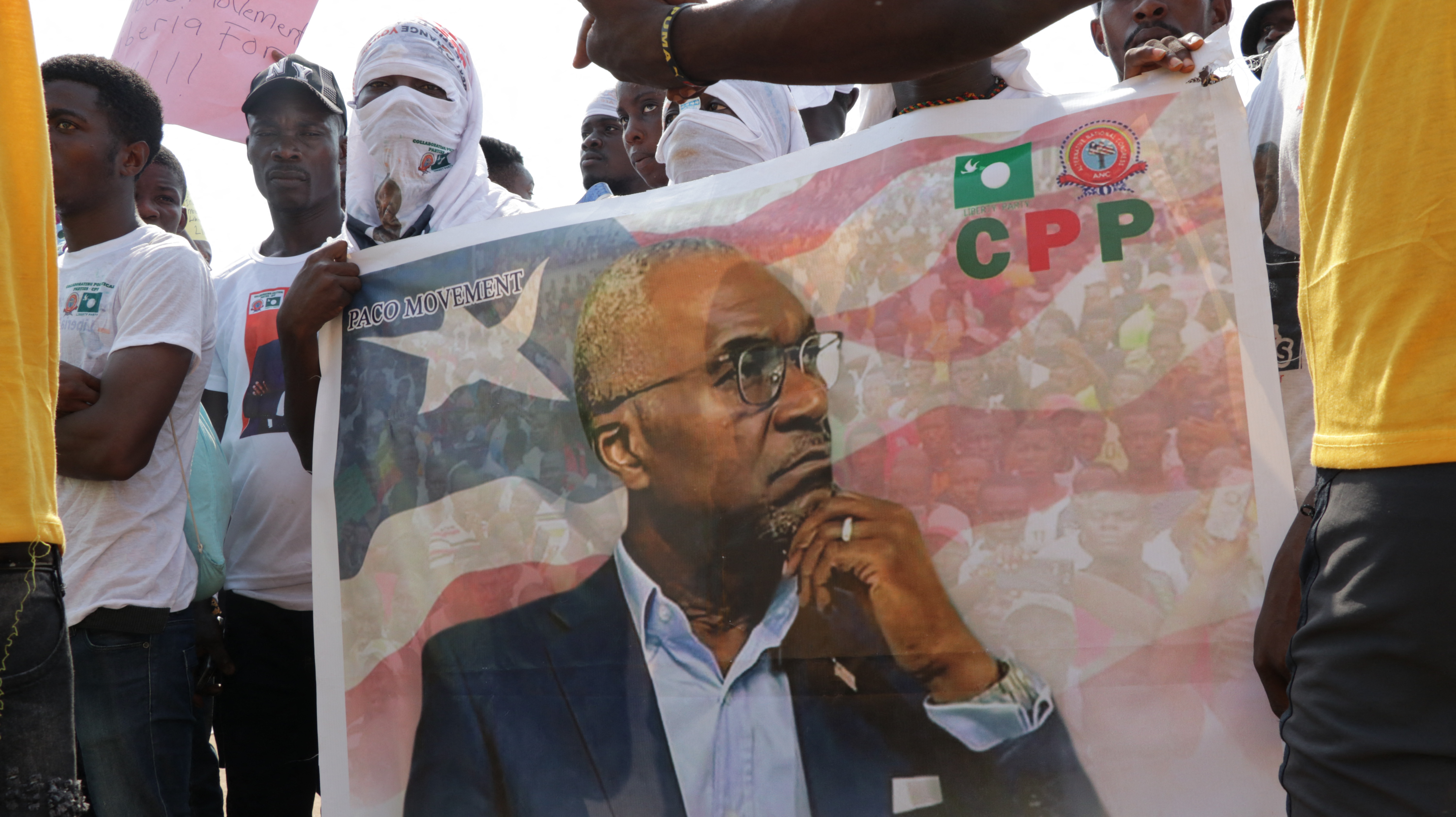 Supporters hold a banner bearing a portrait of Alexander B. Cummings during a rally against living conditions in the capital Monrovia on December 17, 2022