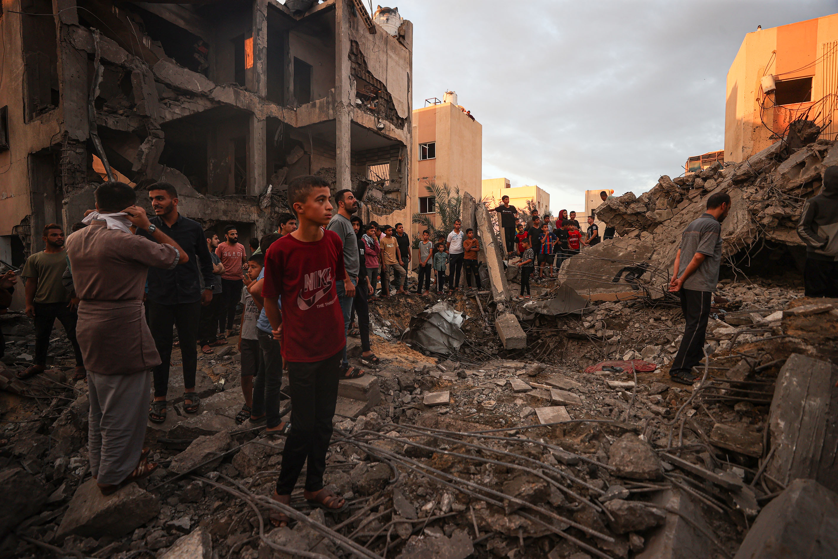 Civil defense members and residents conduct search and rescue operation amid rubble and destroyed buildings after Israeli attacks continue on the 11th day in Khan Yunis