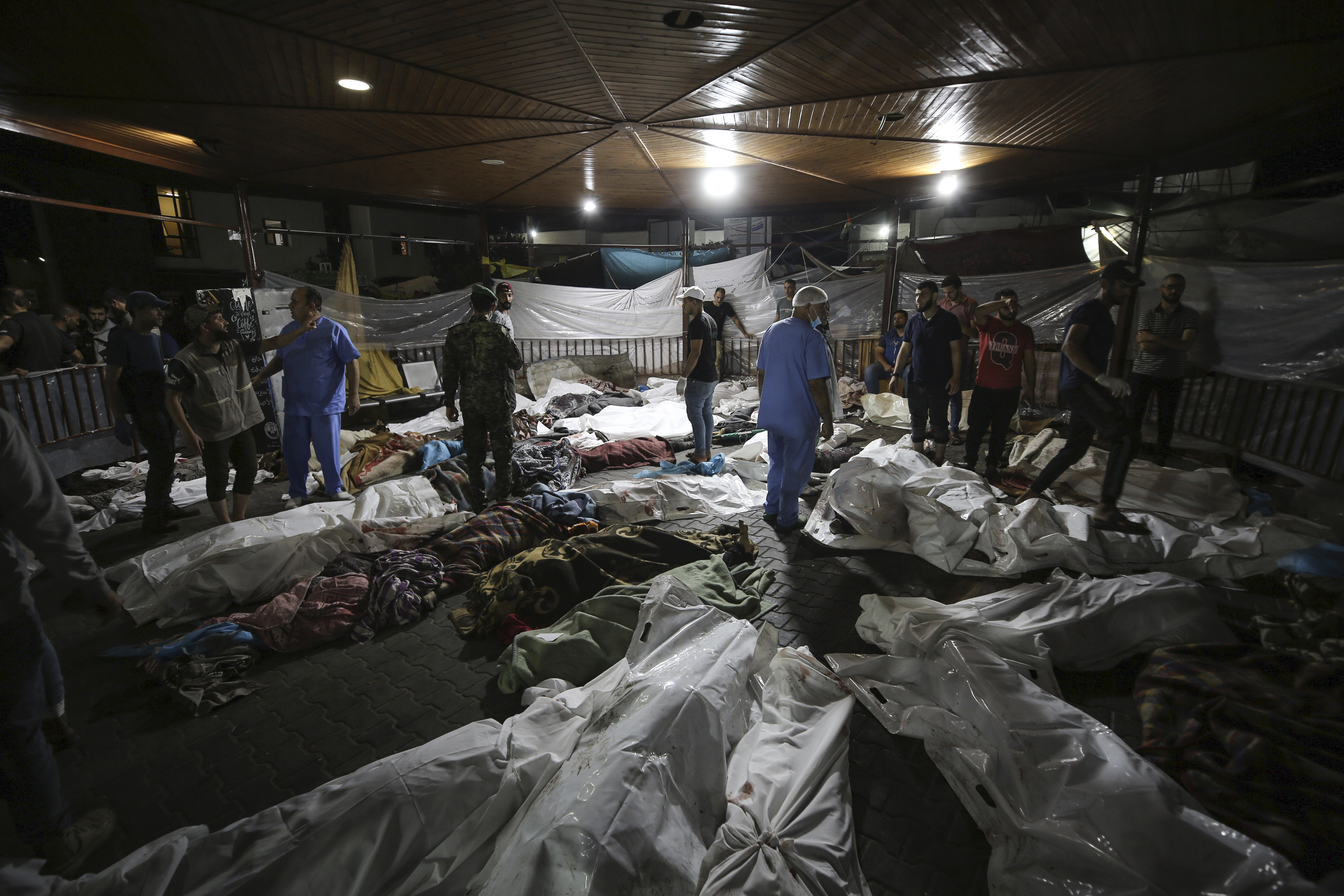 Bodies of Palestinians killed by an explosion at the Ahli Arab hospital are gathered in the front yard of the al-Shifa hospital, in Gaza City