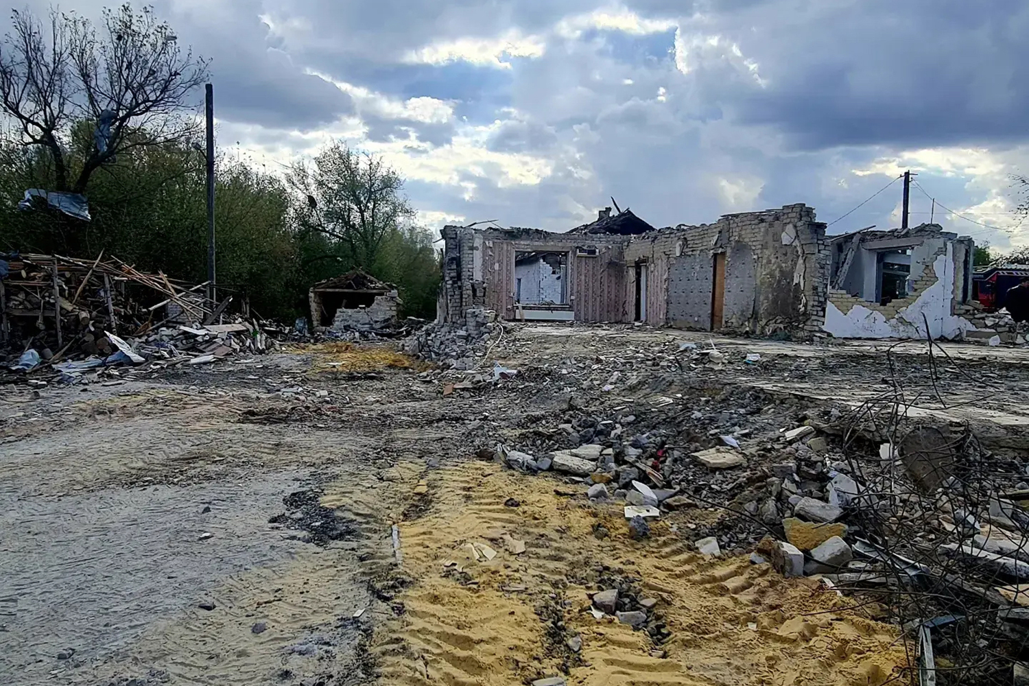 A photo of destroyed buildings and a debris all around the outside of it.