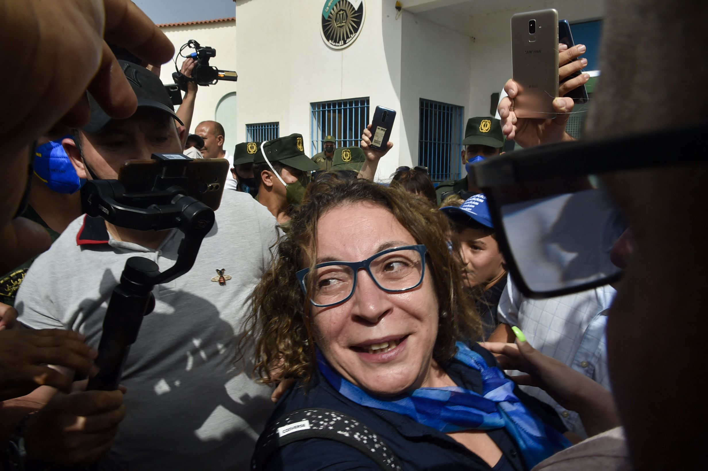 Amira Bouraoui in the middle of a media scrum as she exits the prison
