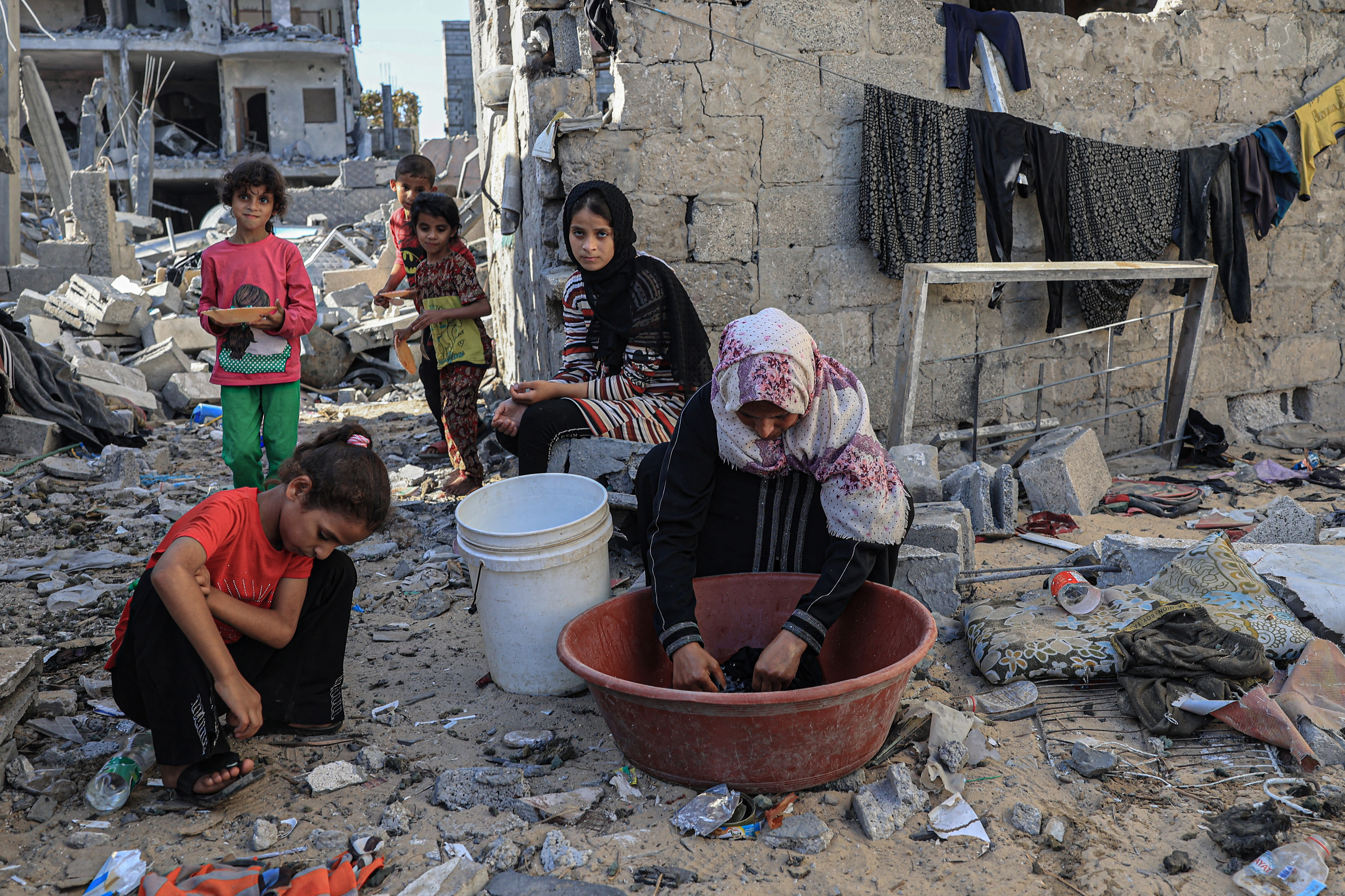 Amal al-Robayaa (R), washes clothes
