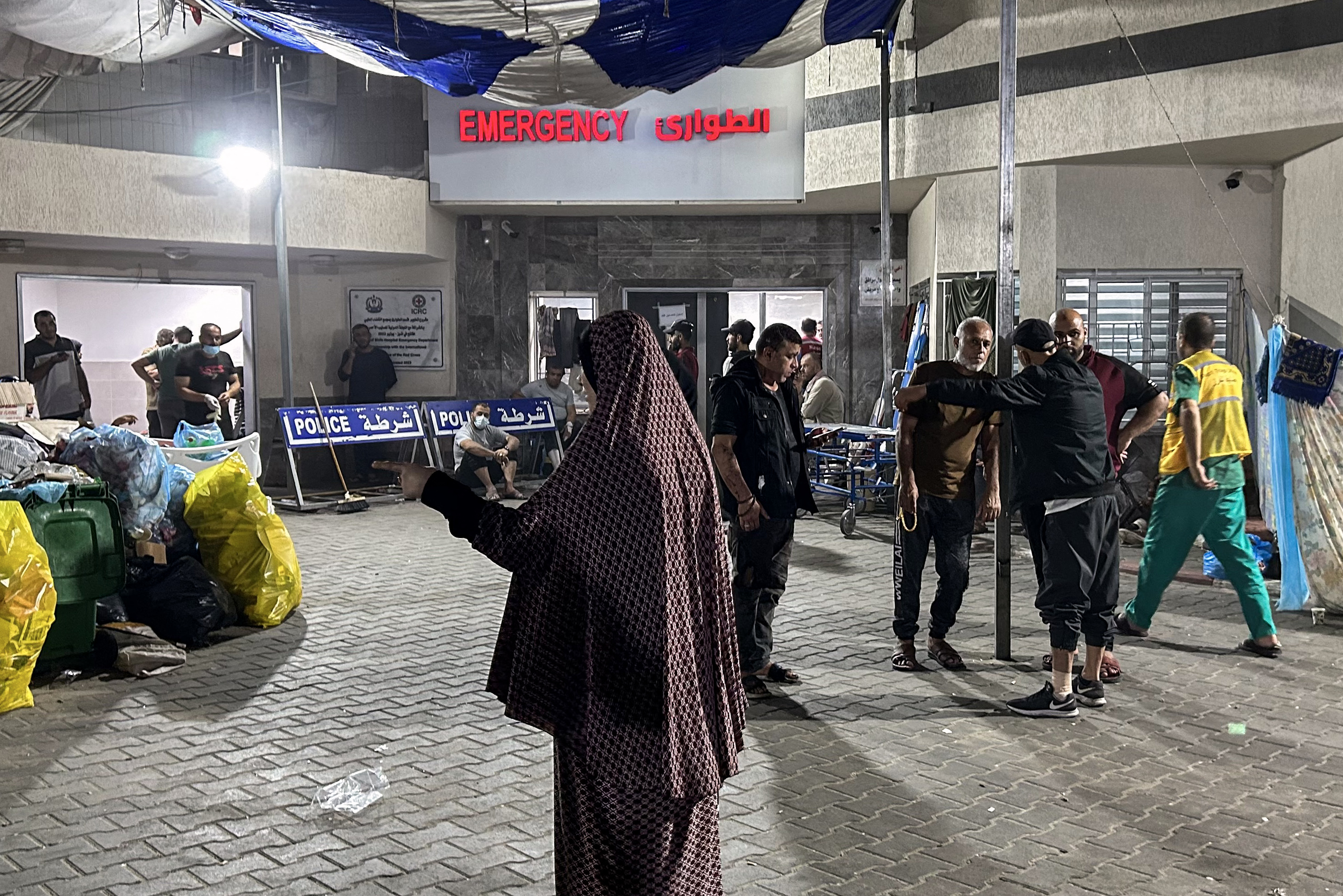 People stand outside the emergency ward of Al-Shifa hospital in Gaza City