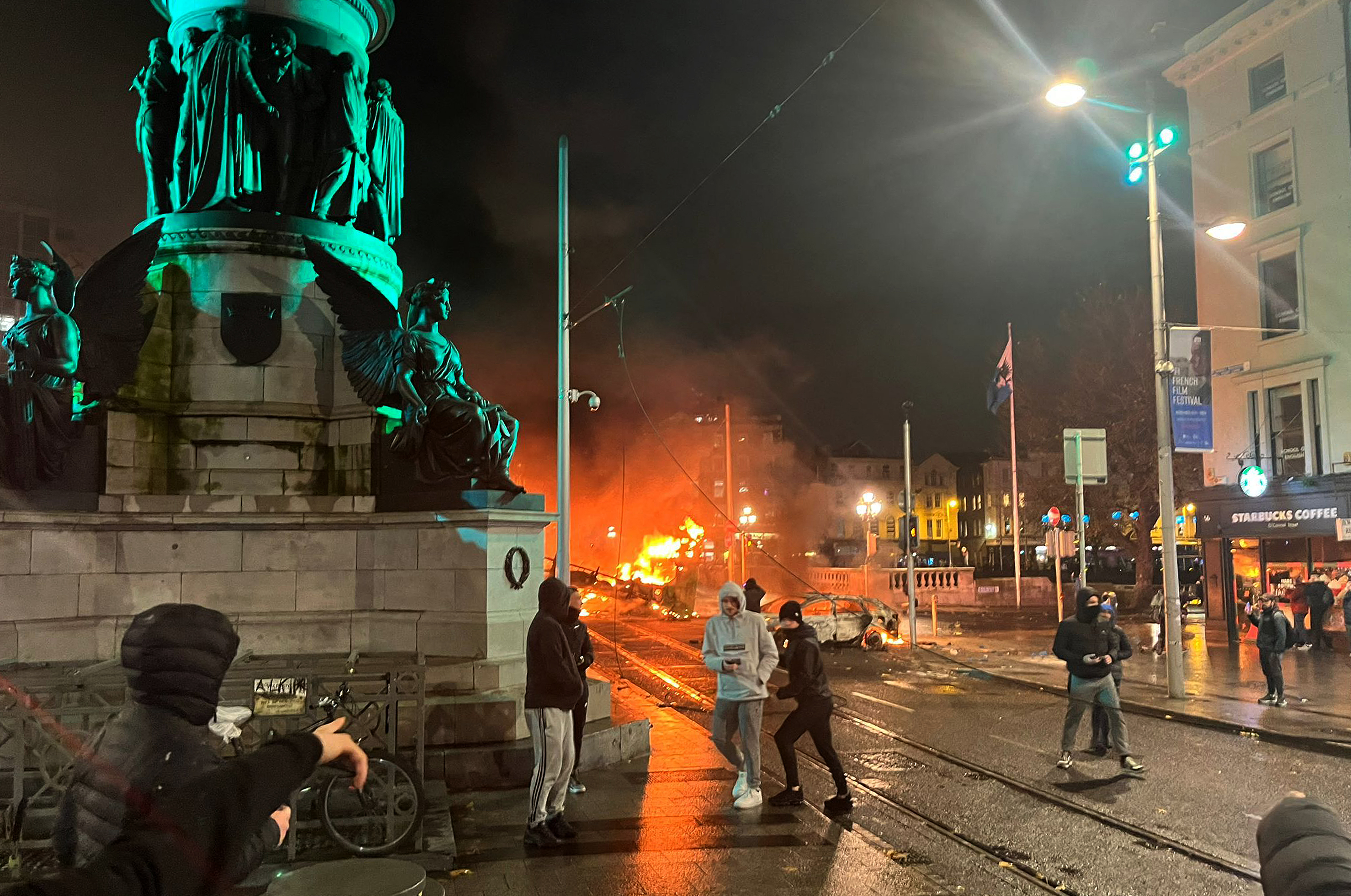 Flames rise from a car and a bus