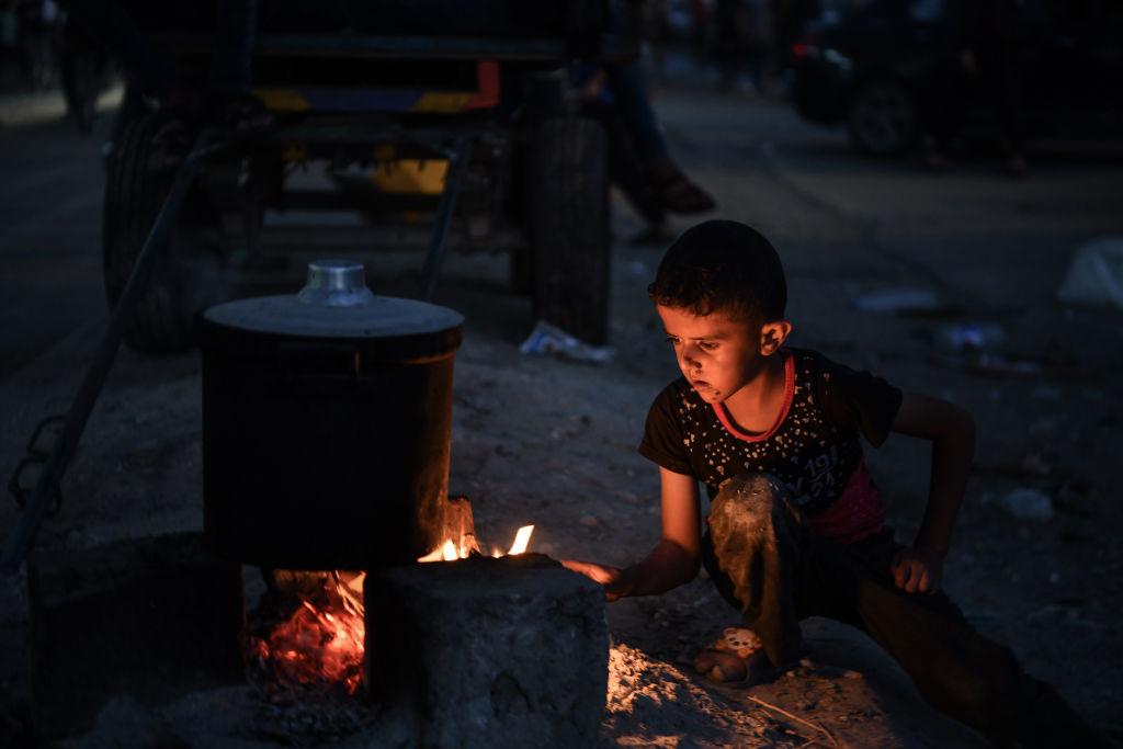 Palestinians who left their houses and live at the Nassr hospital, are trying to feed their children during food shortages as the Israeli attacks continue in Gaza City, Gaza.