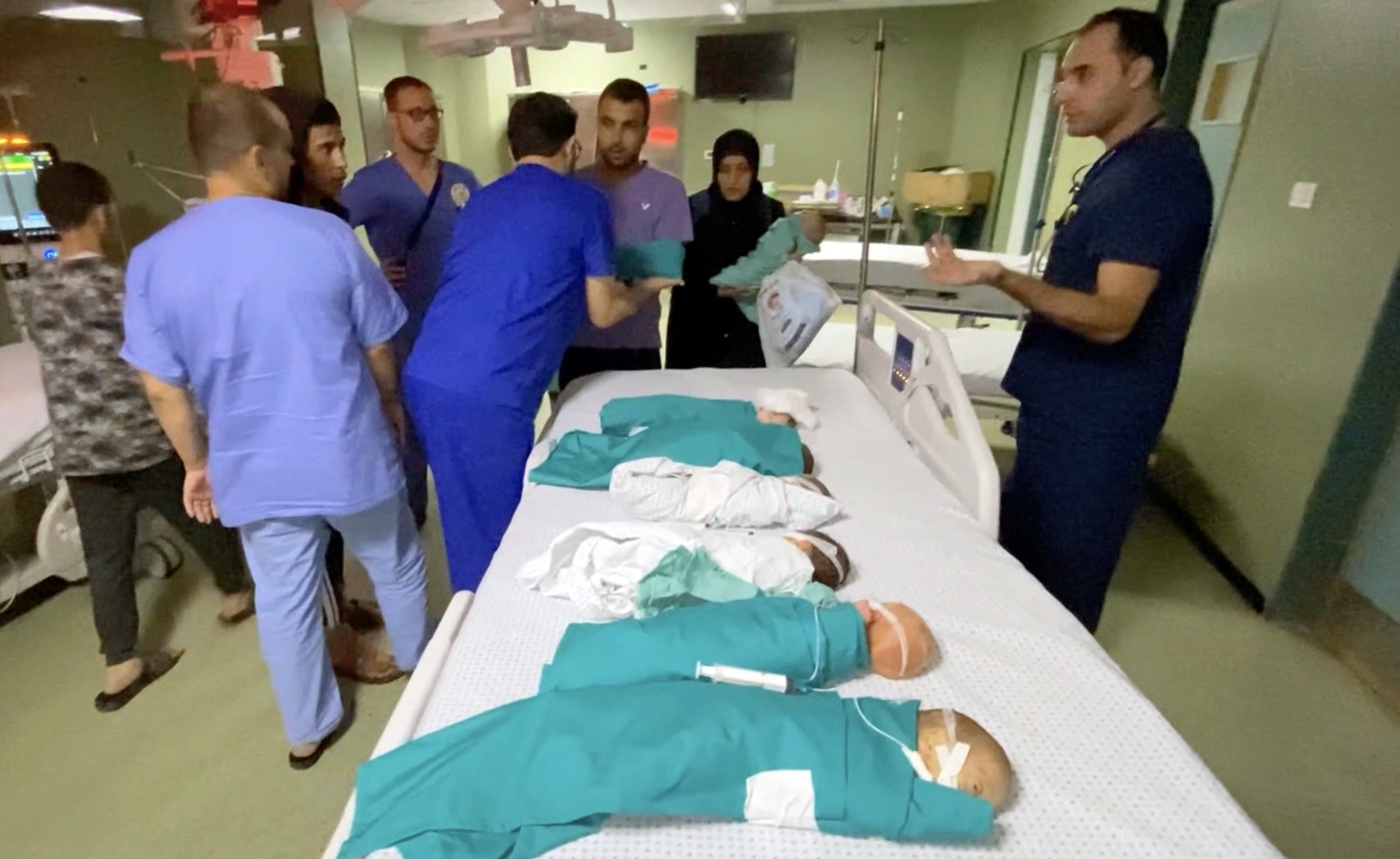 A row of babies and medica staff helping them