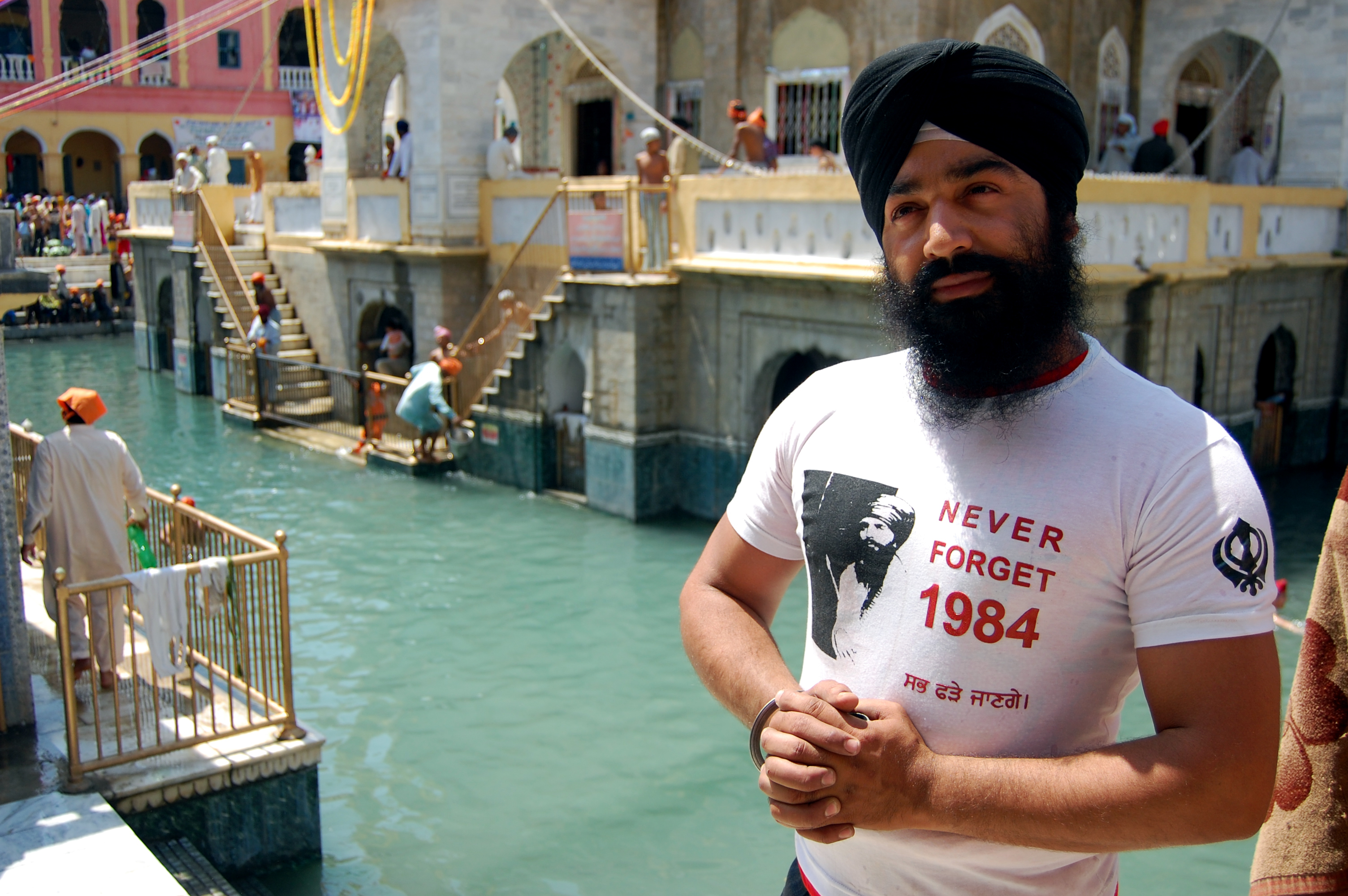 Pakistani Sikh Surjeet Singh wears a T-shirt commemorating the deadly 1984 Indian army raid on the Golden Temple during a visit to the Gurdwara Panja Sahib and its sacred pond in Hasan Abdal, Punjab, Pakistan