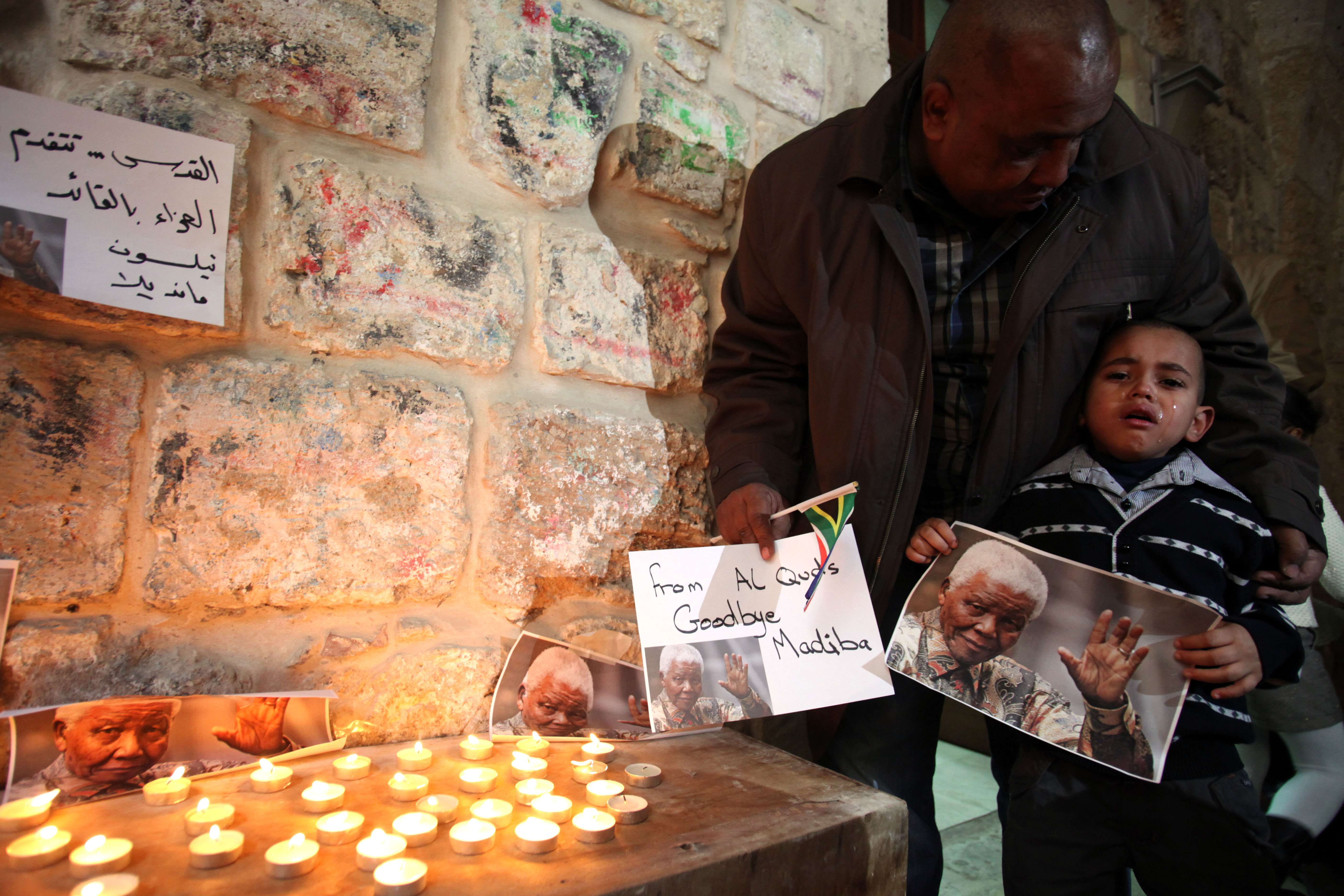 Palestinians gather at a candle memorial for Mandela in an area of Jerusalem’s Old City popular with Africans, on December 7, 2013, two days after the Nobel Peace Prize winner’s death
