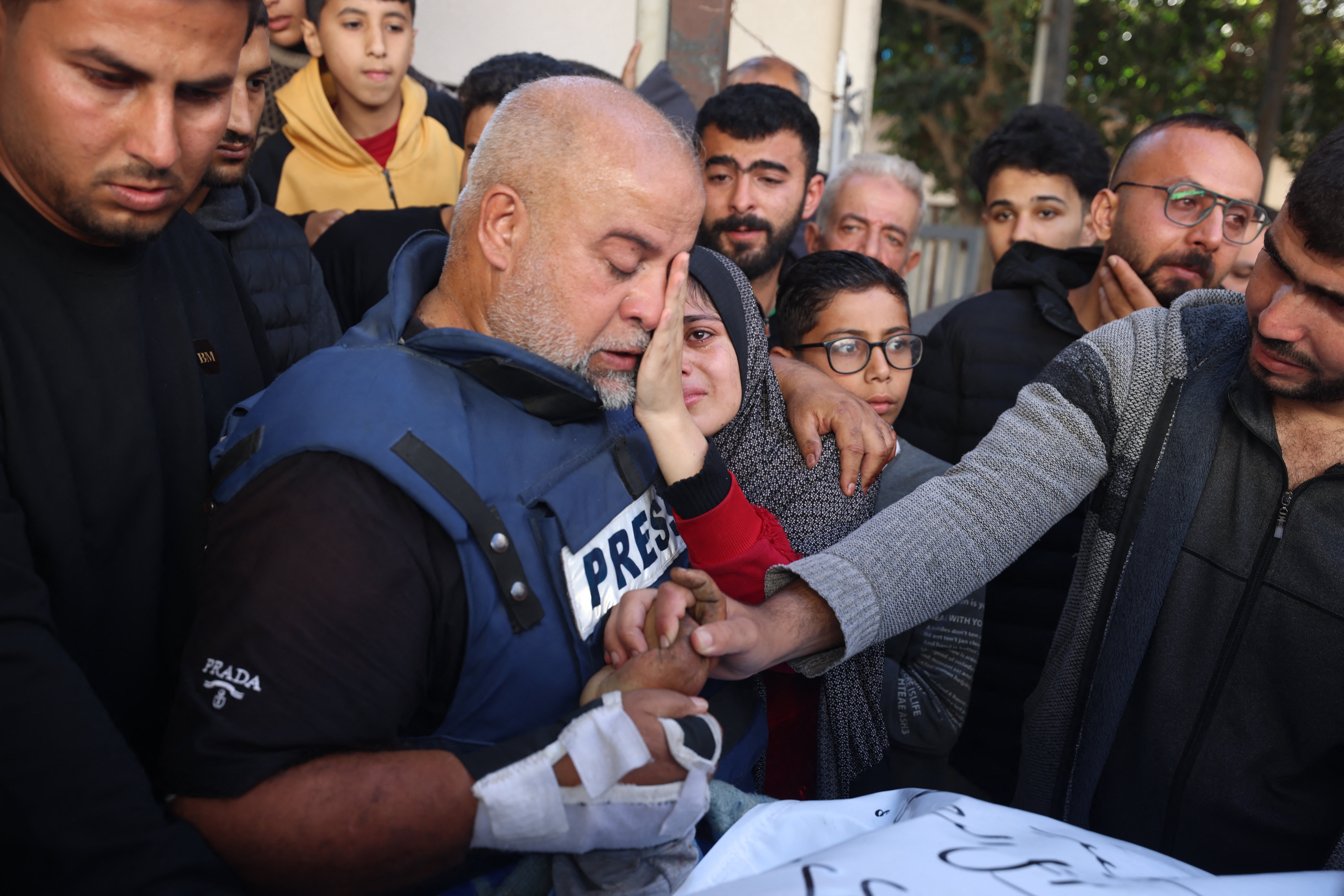 Al Jazeera’s bureau chief in Gaza, Wael Dahdouh, centre, hugs his daughter during the funeral of his son Hamza Wael Dahdouh, a journalist with the Al Jazeera television network, who was killed in a reported Israeli air strike in Rafah in the Gaza Strip on January 7, 2024 [AFP]