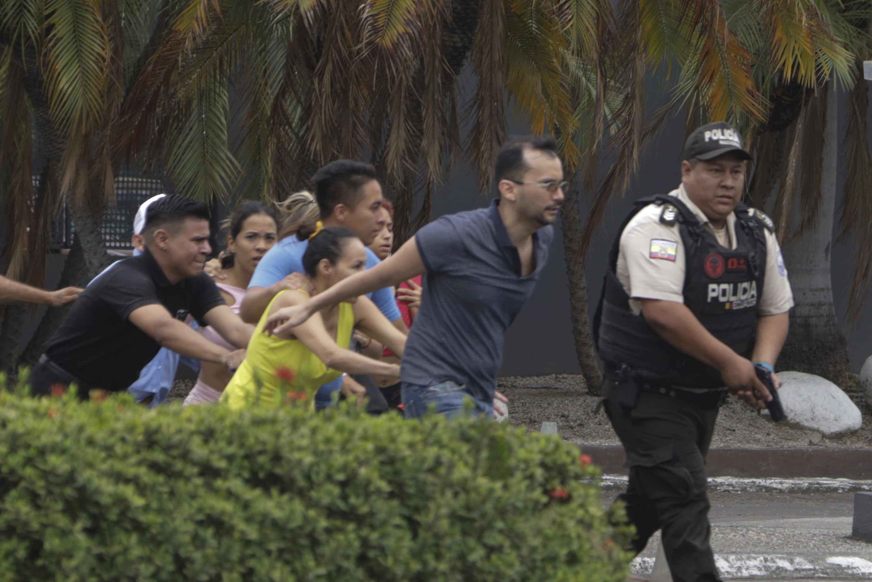 Employees from TC television channel evacuate their station in Guayaquil, Ecuador, on January 9 after masked gunmen broke in during a live broadcast