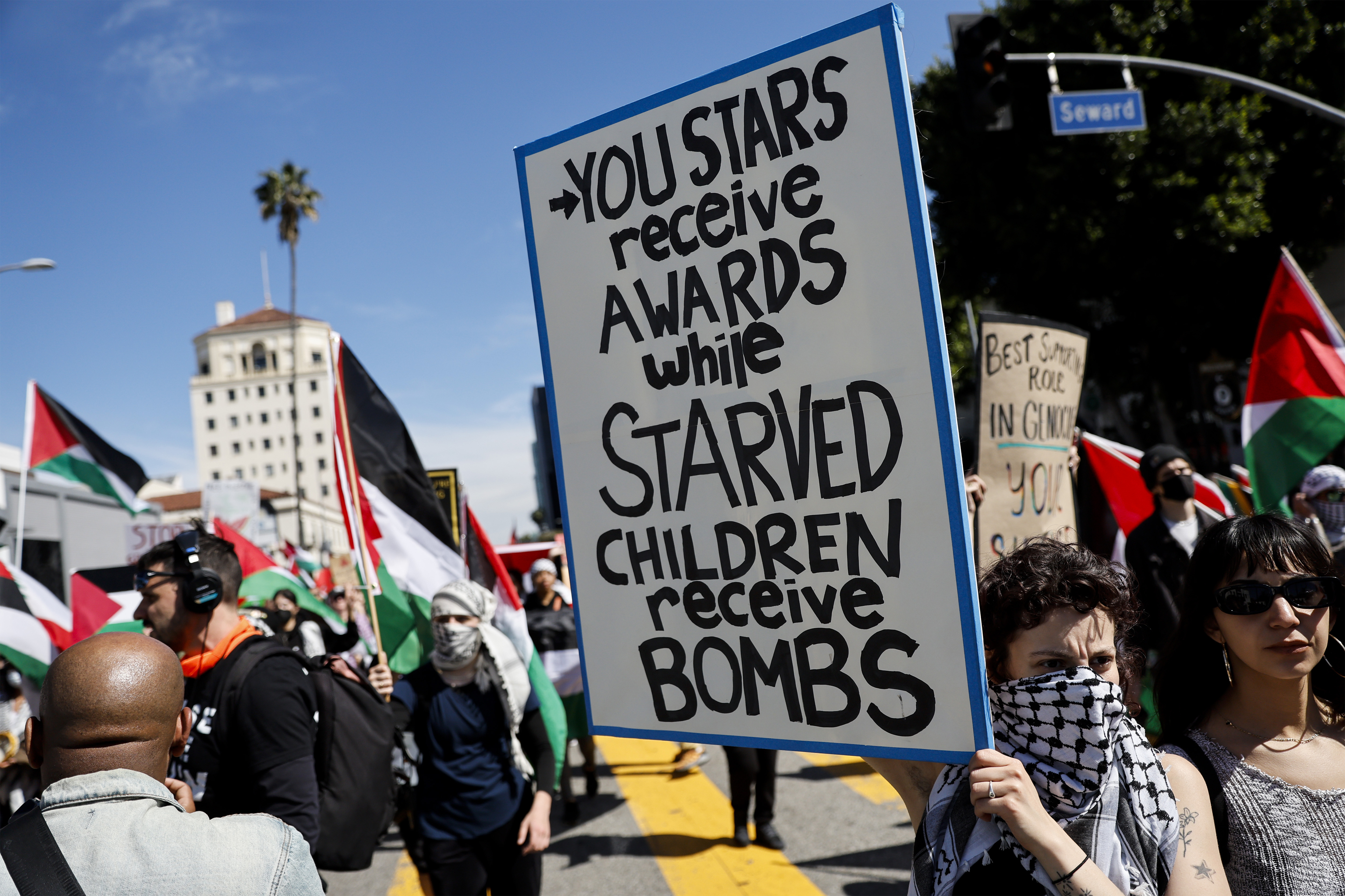 A protester holds a poster during a demonstration in support of Palestinians calling for a ceasefire in Gaza, near the Dolby Theatre on March 10, 2024