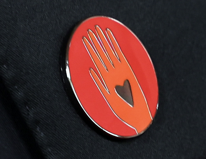 A red pin worn to Call for a Cease-Fire in Gaza arriving on the red carpet at the 96th Annual Academy Awards in Dolby Theatre at Hollywood