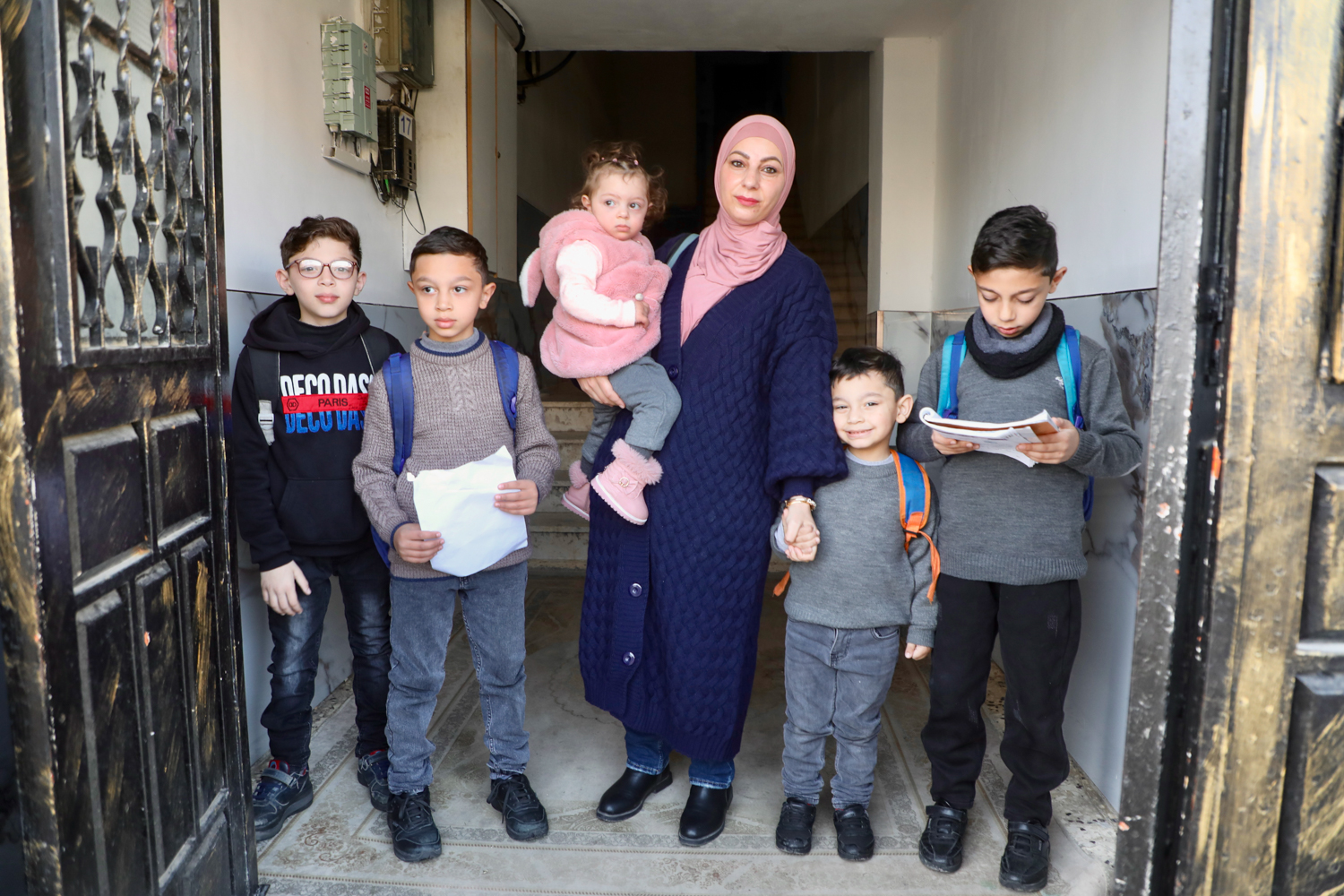 Lina Amro with her children as they leave their building to start their days