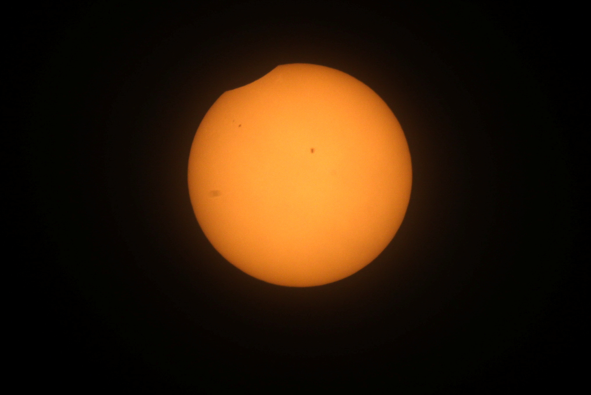 The sun begins to be overshadowed — just barely — by the moon.