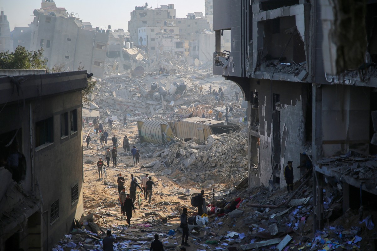 Palestinians gather around the burned and destroyed Al-Shifa Hospital