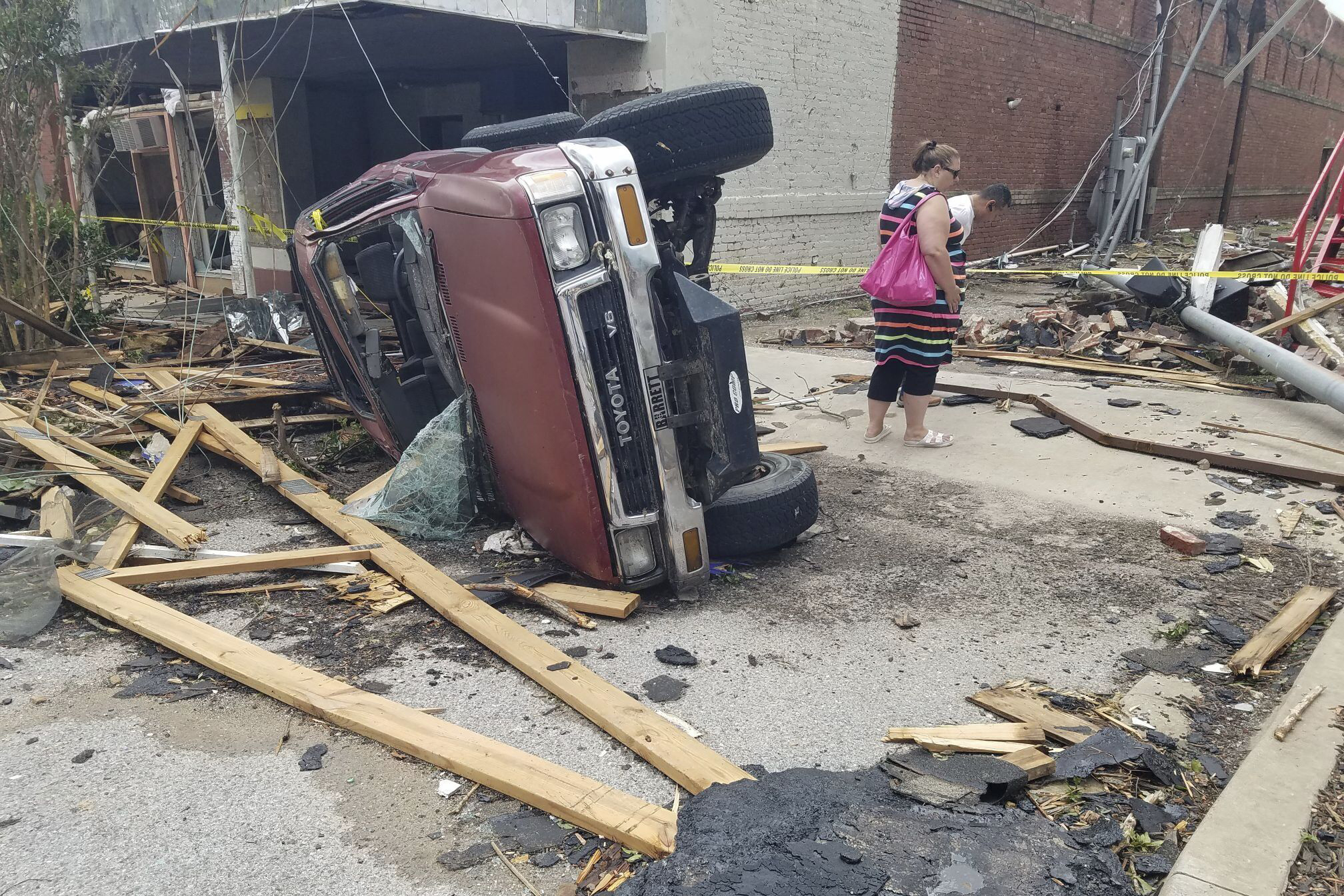 A car lies on its side after a tornado tossed it into the air