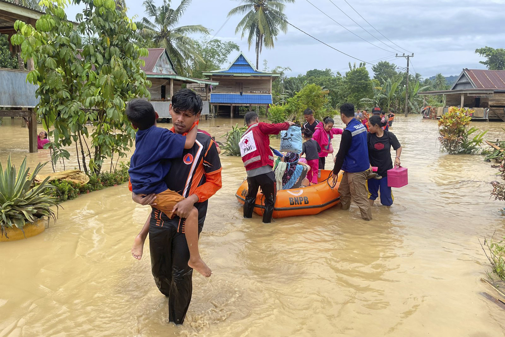 In this Friday, May 3, 2024, photo released by the Wajo Regional Disaster Management Agency (BPBD Wajo), rescuers carry a victim of a flood in Wajo, South Sulawesi, Indonesia. A flood and a landslide hit Indonesia's Sulawesi island, killing a number of people, officials said Saturday. (BPBD Wajo via AP)