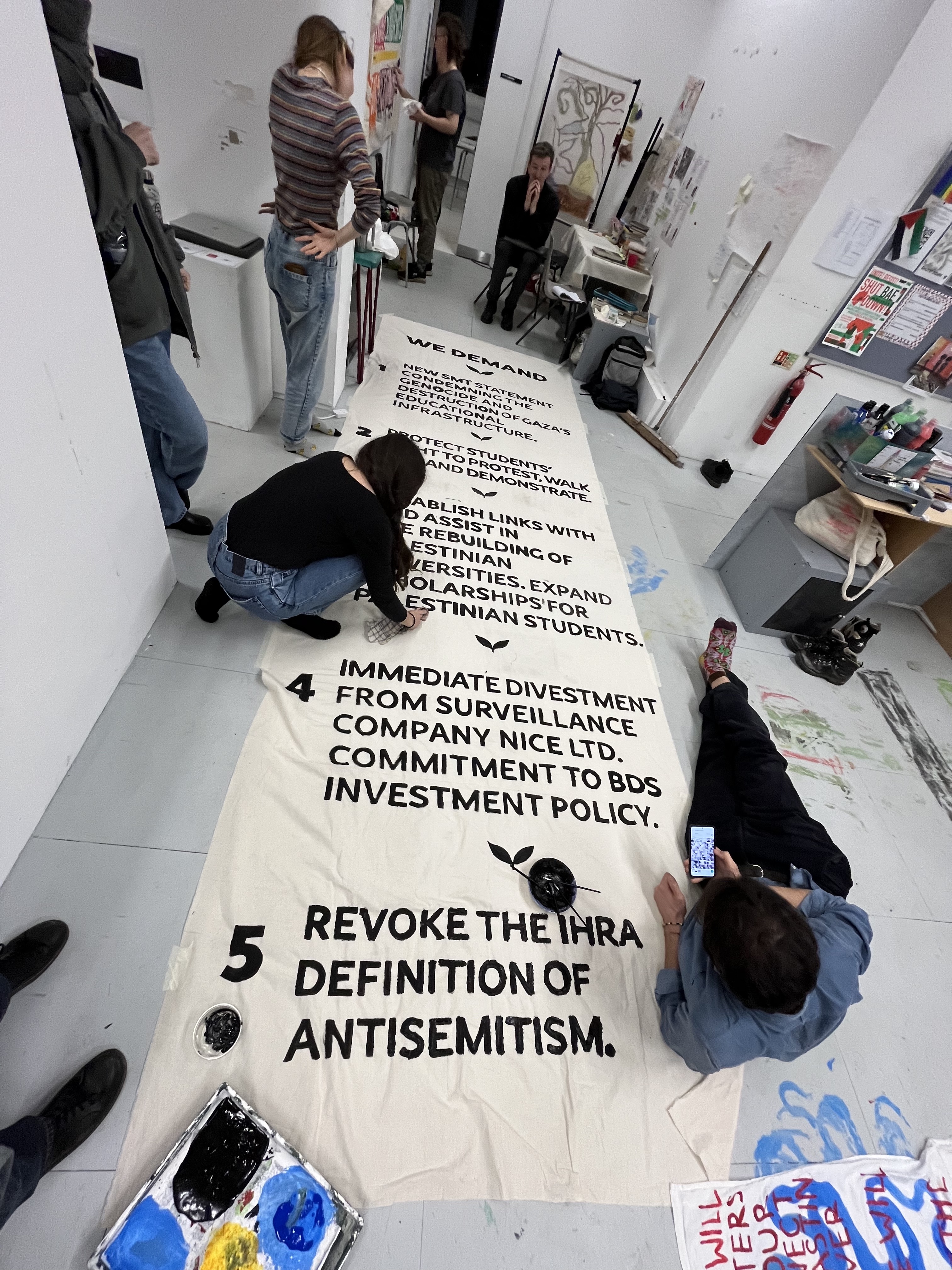 Students at Goldsmiths University are pictured making a banner listing their demands [Courtesy of Goldsmiths for Palestine]
