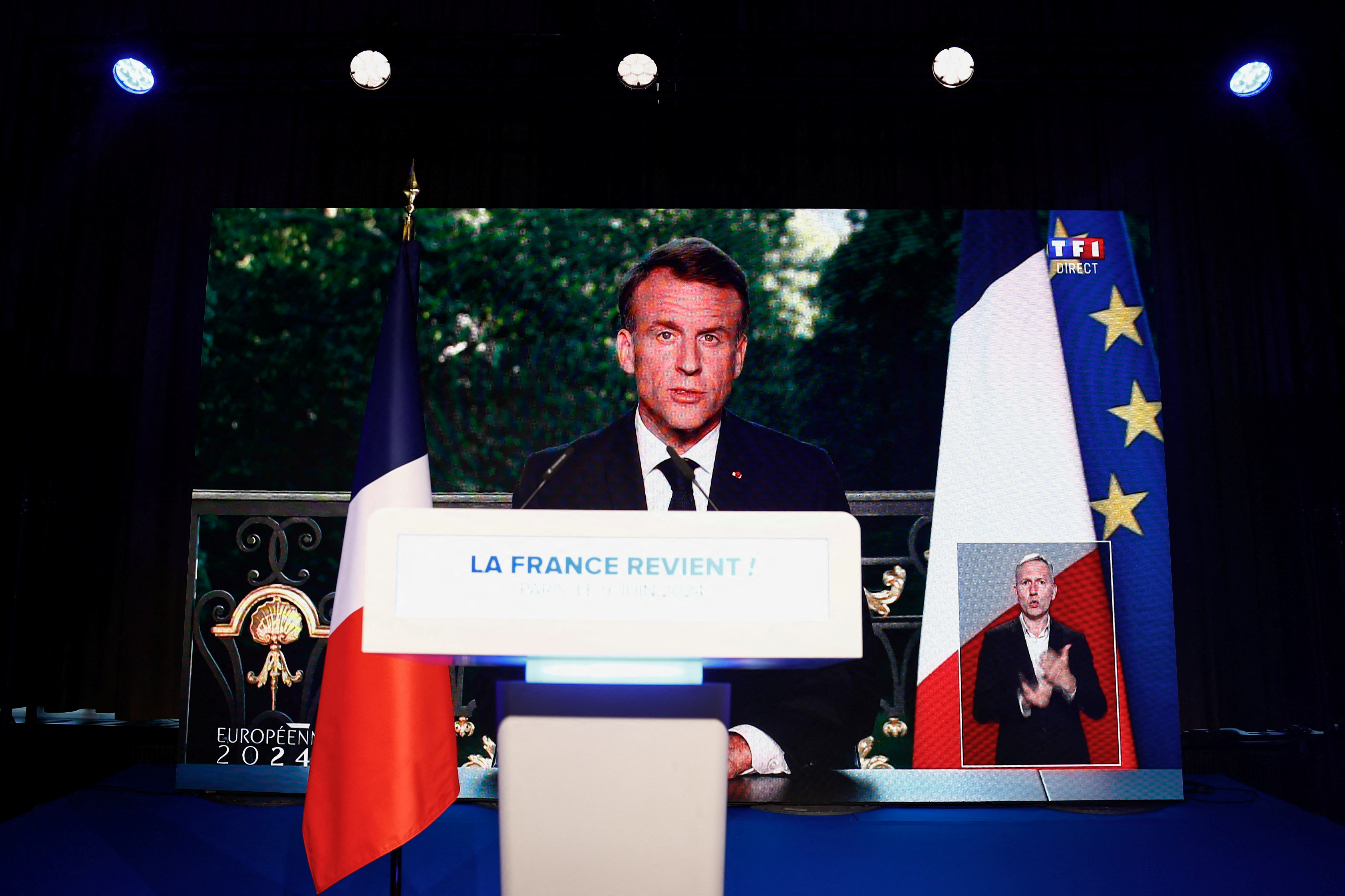 French President Emmanuel Macron, seen on a screen at the far-right National Rally party headquarters, speaks after the polls closed during the European Parliament elections on Sunday, June 9, 2024
