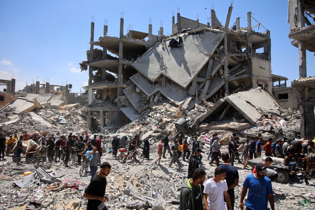 Palestinians carry some salvaged belongings as they leave the Jabalia