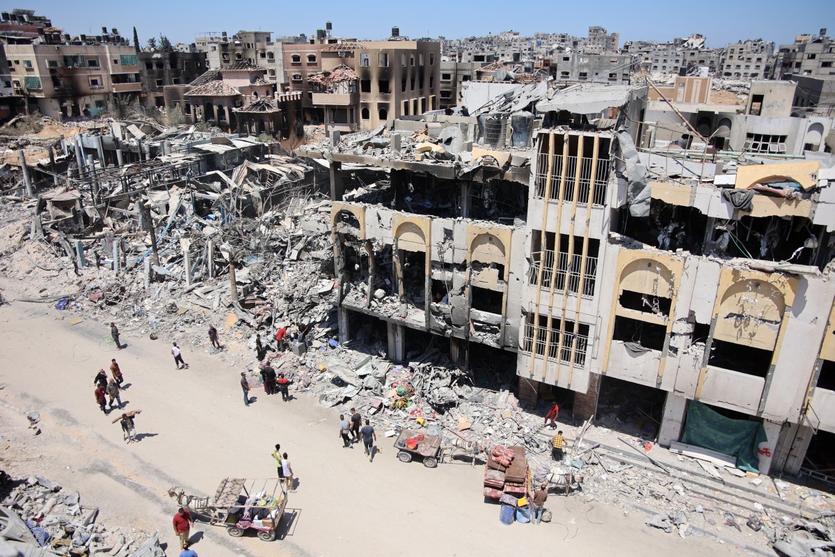 Palestinians carry some salvaged belongings as they leave the Jabalia refugee camp