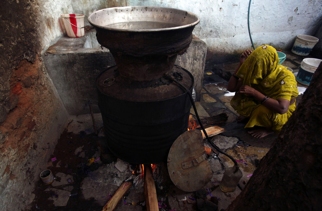 An Indian woman prepares Gudumba, local illicit liquor in the southern Indian state of Andhra Pradesh