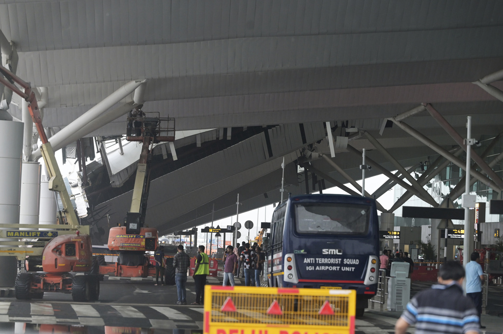 A crew inspects the damage to a part of a departure terminal canopy at New Delhi’s Indira Gandhi International Airport that collapsed
