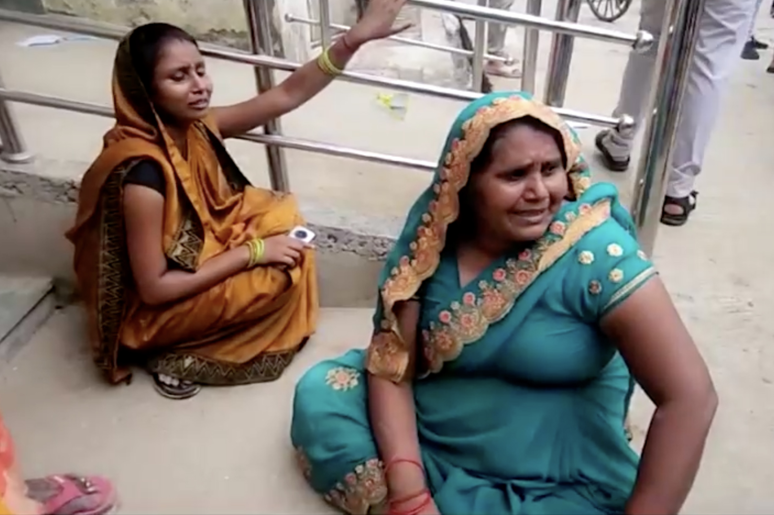 People mourn the death of their relatives outside a hospital in Hathras [Screengrab via Reuters]