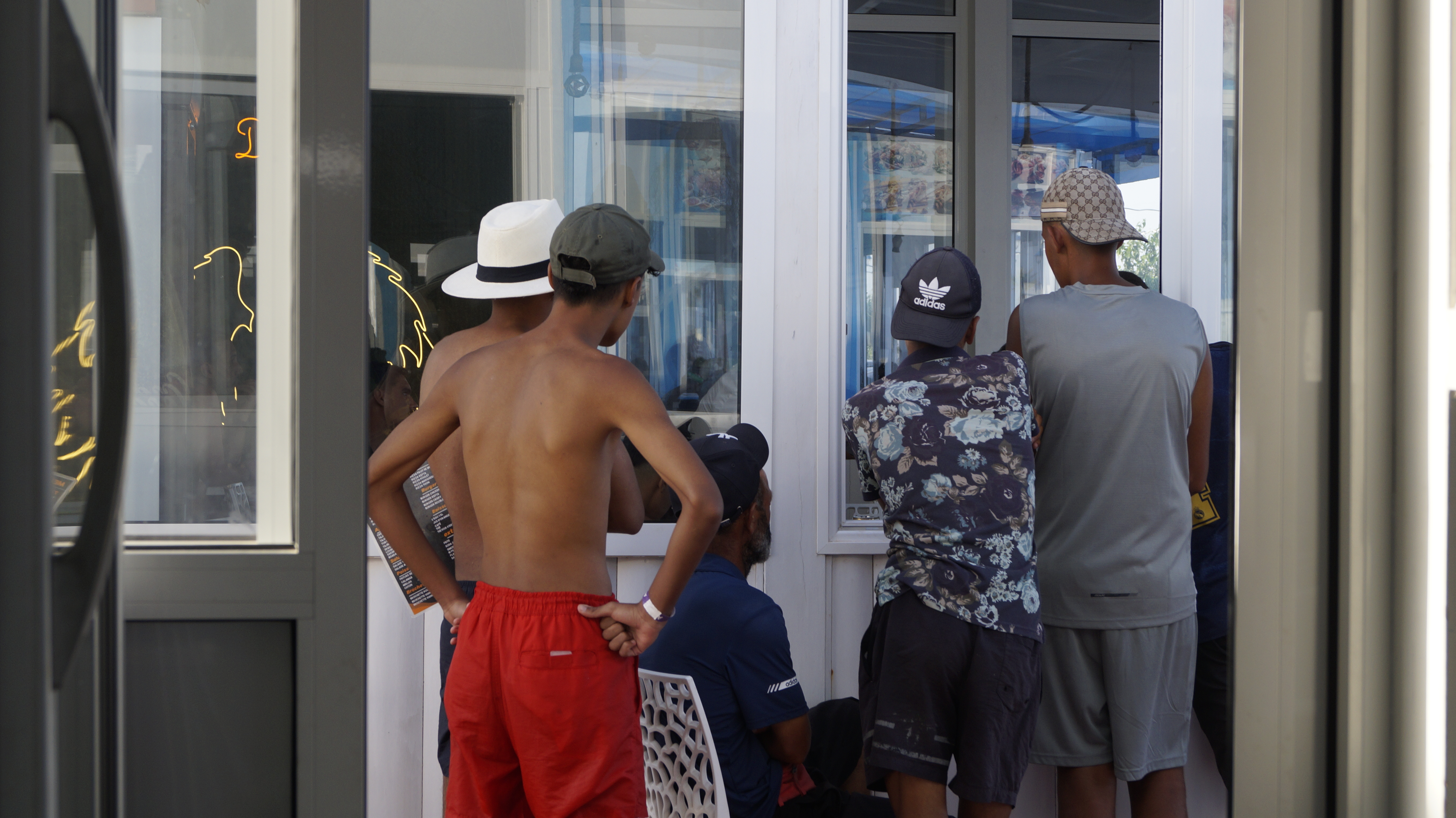 Teenagers at the beach restaurant where Ilyas’s mother, Aseya, works watch the television as Spain’s football team plays against Morocco. They dream of one day crossing to the land they can see from the shore of their own beach